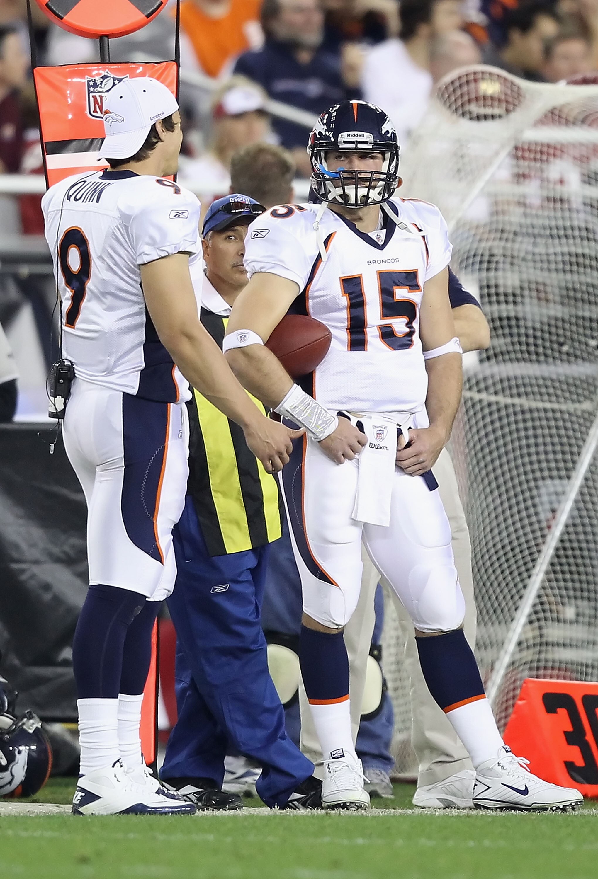 GLENDALE, AZ - DECEMBER 12:  Quarterbacks Brady Quinn #9 and Tim Tebow #15 of the Denver Broncos stand on the sideline during the NFL game against the Arizona Cardinals at the University of Phoenix Stadium on December 12, 2010 in Glendale, Arizona.   The