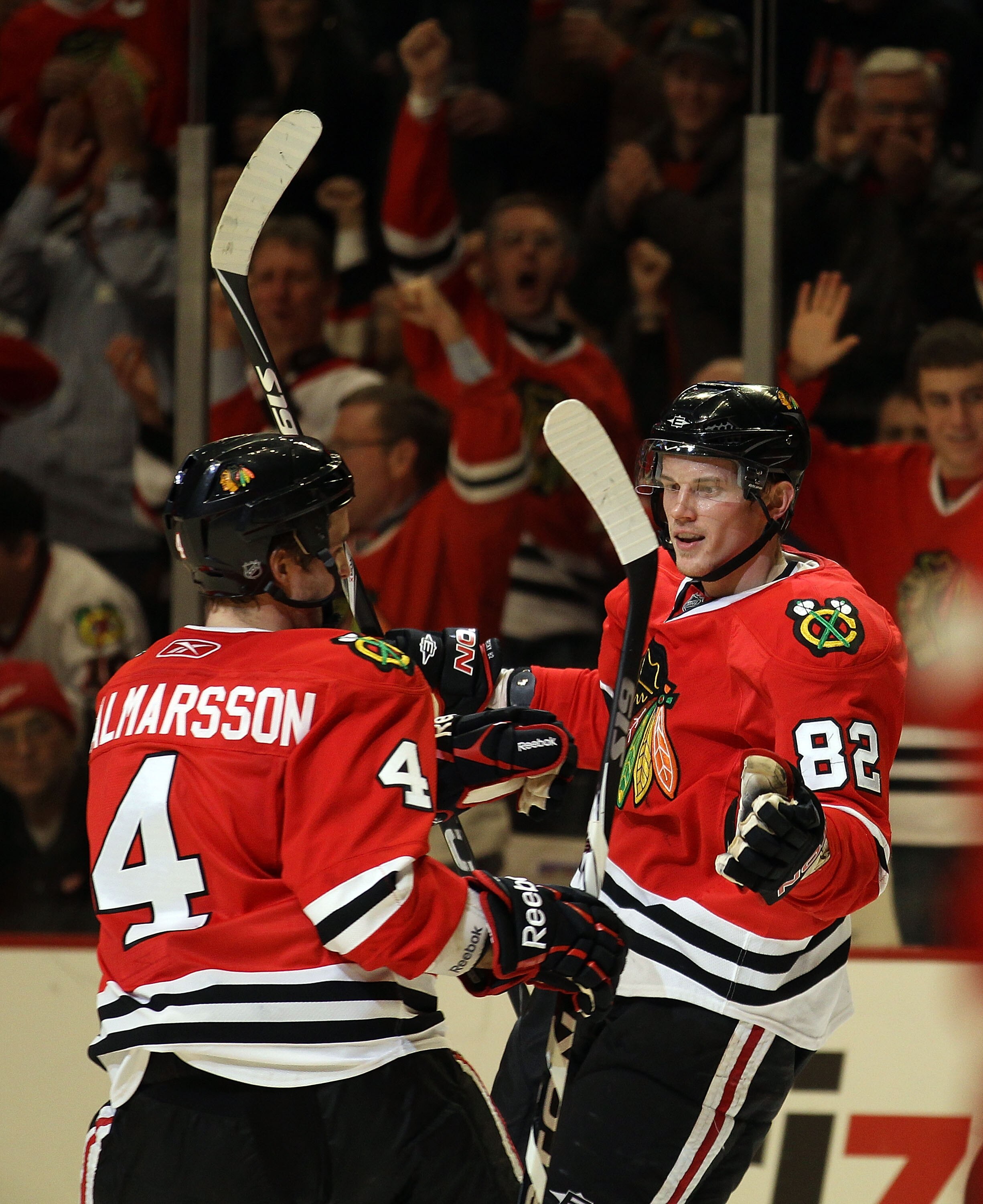 CHICAGO, IL - DECEMBER 17: Tomas Kopecky #82 of the Chicago Blackhawks celebrates a goal with teammate Niklas Hjalmarsson #4 against the Detroit Red Wings at the United Center on December 17, 2010 in Chicago, Illinois. The Blackawks defeated the Red Wings