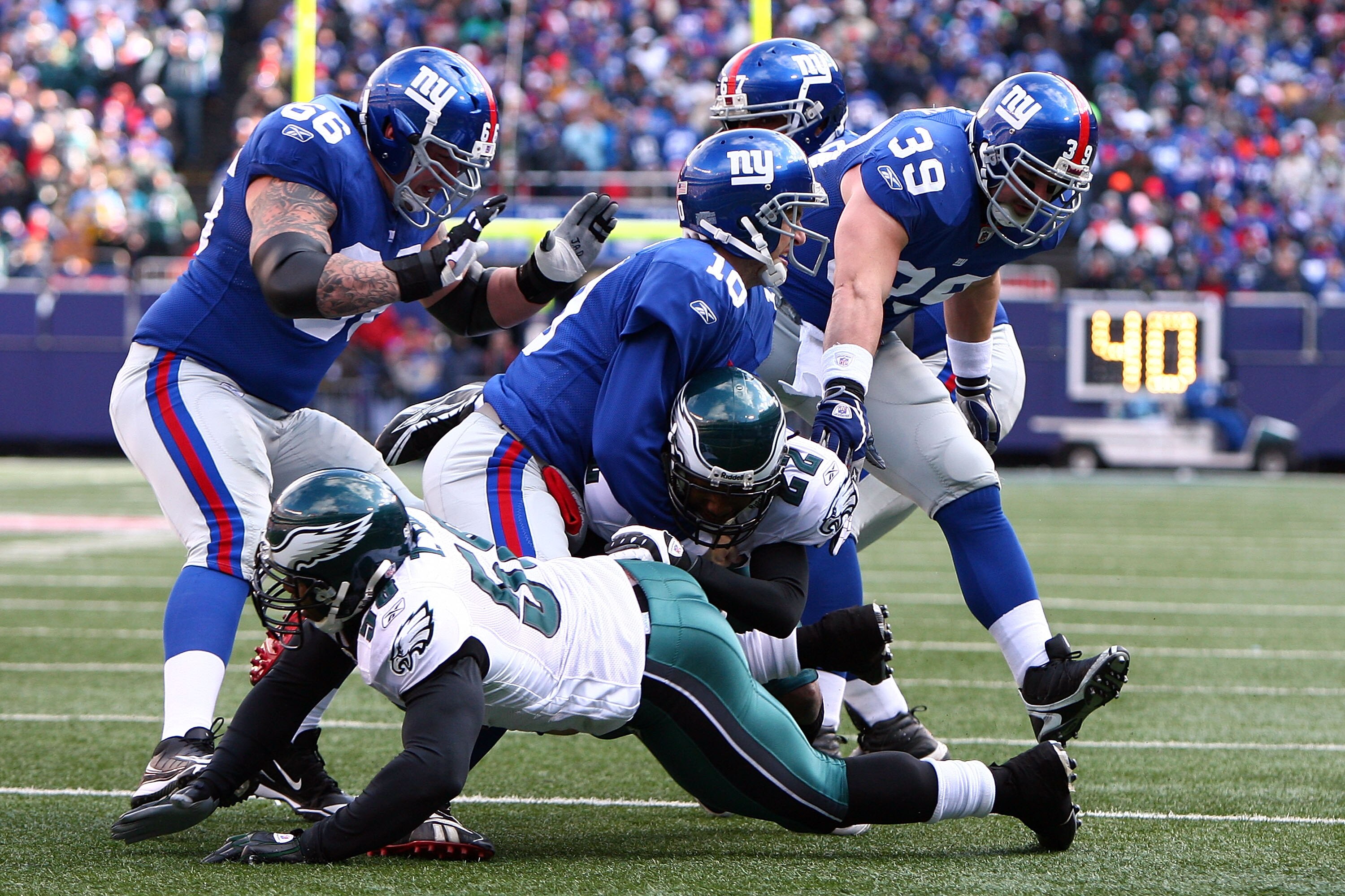 EAST RUTHERFORD, NJ - JANUARY 11:  Asante Samuel #22 of the Philadelphia Eagles is tackled by Eli Manning #10 of the New York Giants after making an interception during the NFC Divisional Playoff Game on January 11, 2009 at Giants Stadium in East Rutherfo
