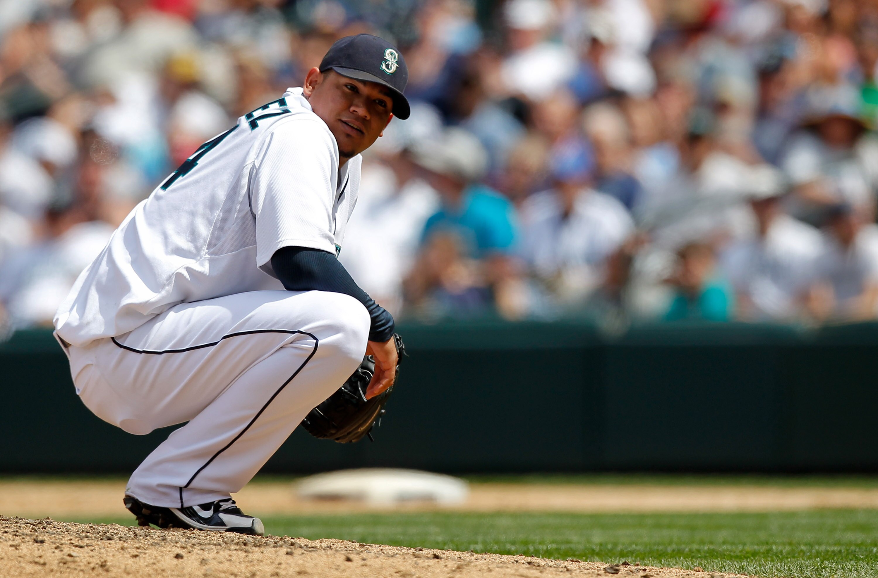 SEATTLE - JUNE 24: Starting pitcher Felix Hernandez #34 of the Seattle Mariners looks back at third baseman Jose Lopez after having to duck his throw to first base on a ground out by Ryan Theriot of the Chicago Cubs at Safeco Field on June 24, 2010 in Sea