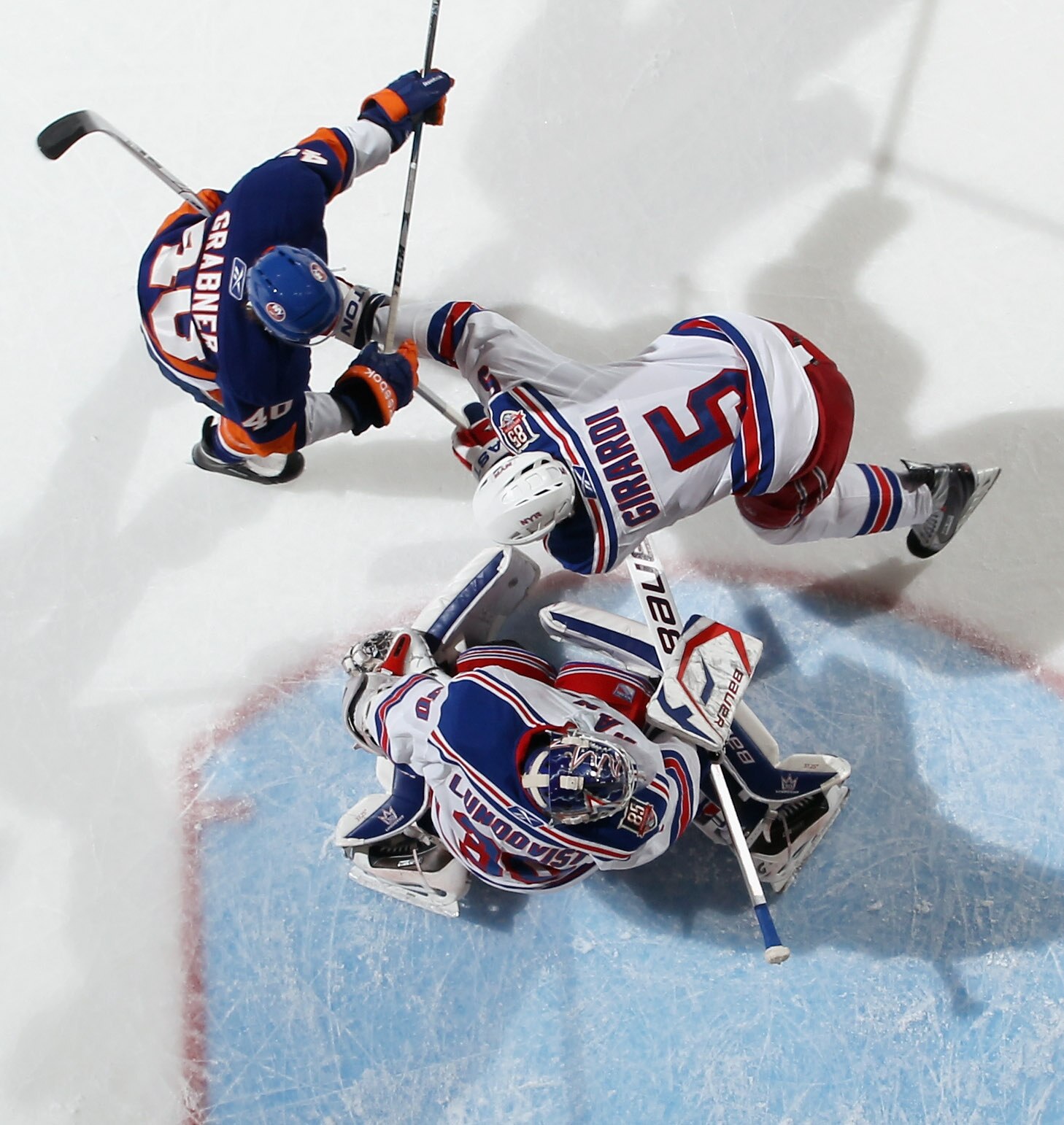 UNIONDALE, NY - DECEMBER 02: Dan Girardi #5 and Henrik Lundqvist #30 of the New York Rangers defend against Michael Grabner #40 of the New York Islanders at the Nassau Coliseum on December 2, 2010 in Uniondale, New York.  (Photo by Bruce Bennett/Getty Ima