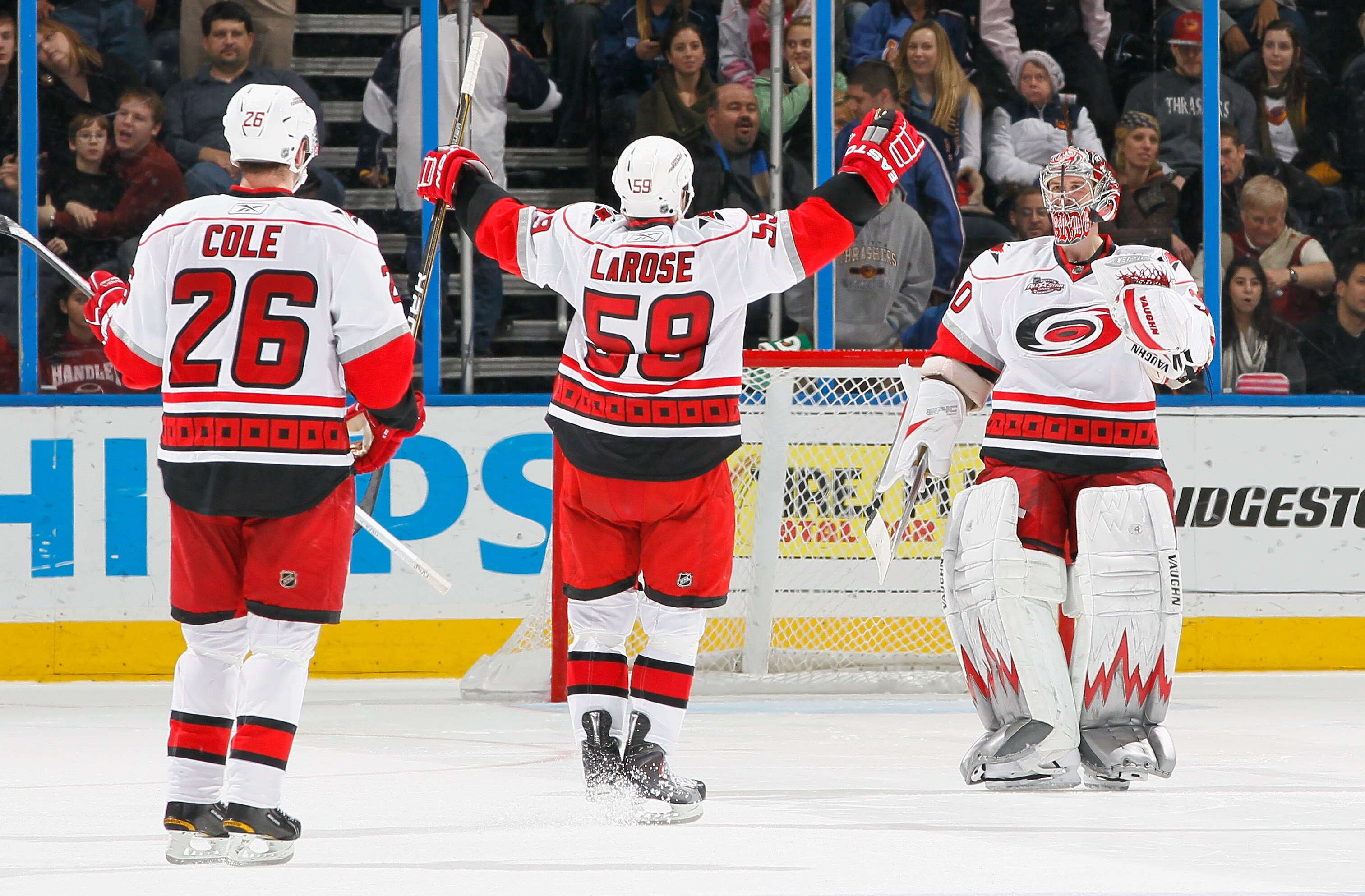 ATLANTA, GA - DECEMBER 16:  Erik Cole #26 and Chad LaRose #59 of the Carolina Hurricanes celebrate towards goaltender Cam Ward #30 after their 3-2 win in a shootout against the Atlanta Thrashers at Philips Arena on December 16, 2010 in Atlanta, Georgia.  
