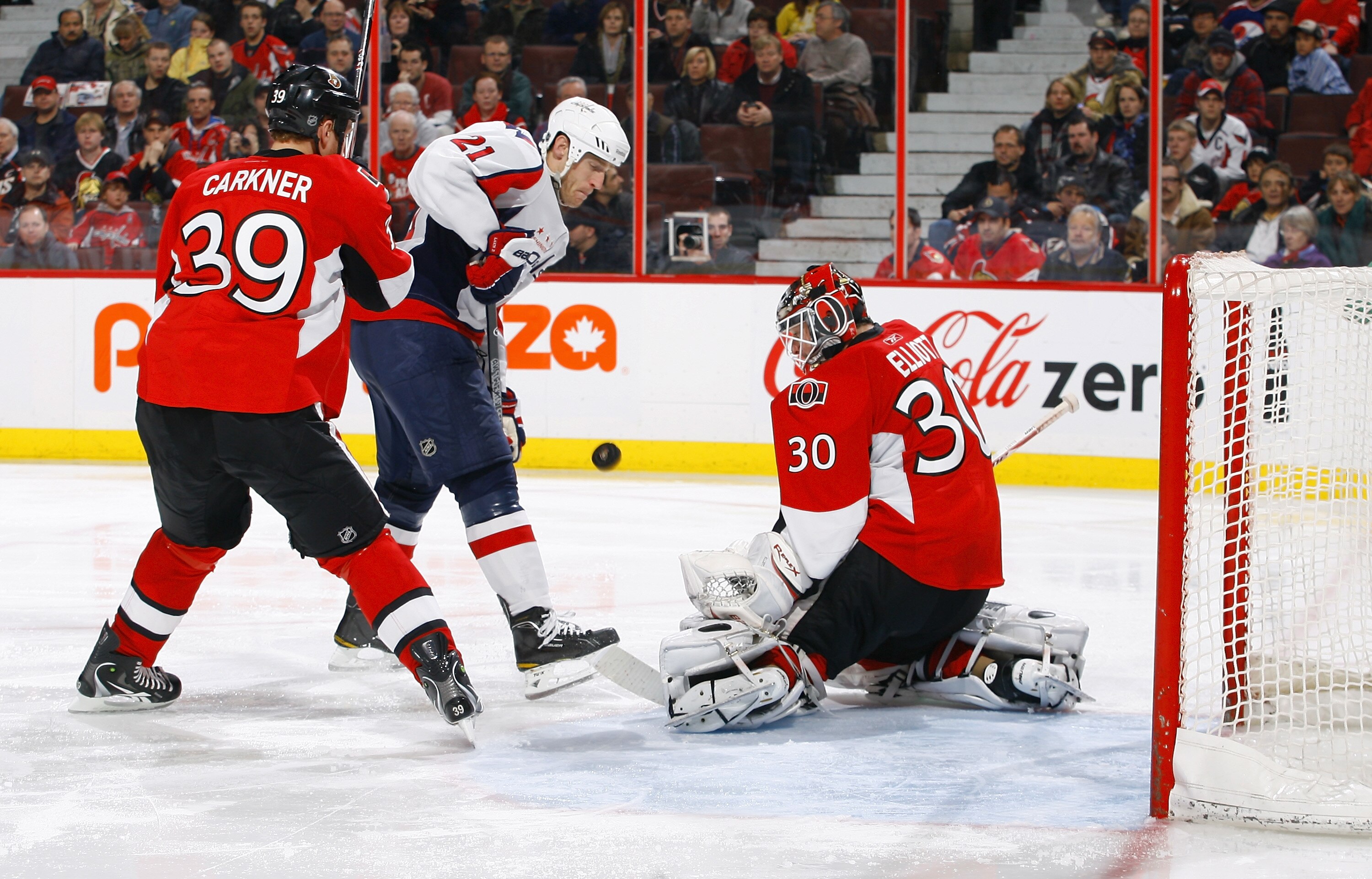 OTTAWA, ON - DECEMBER 19:  Brian Elliott #30 of the Ottawa Senators makes a save while teammate Matt Carkner #39 tries to defend against Brooks Laich #21 of the Washington Capitals in a game at Scotiabank Place on December 19, 2010 in Ottawa, Canada.  (Ph