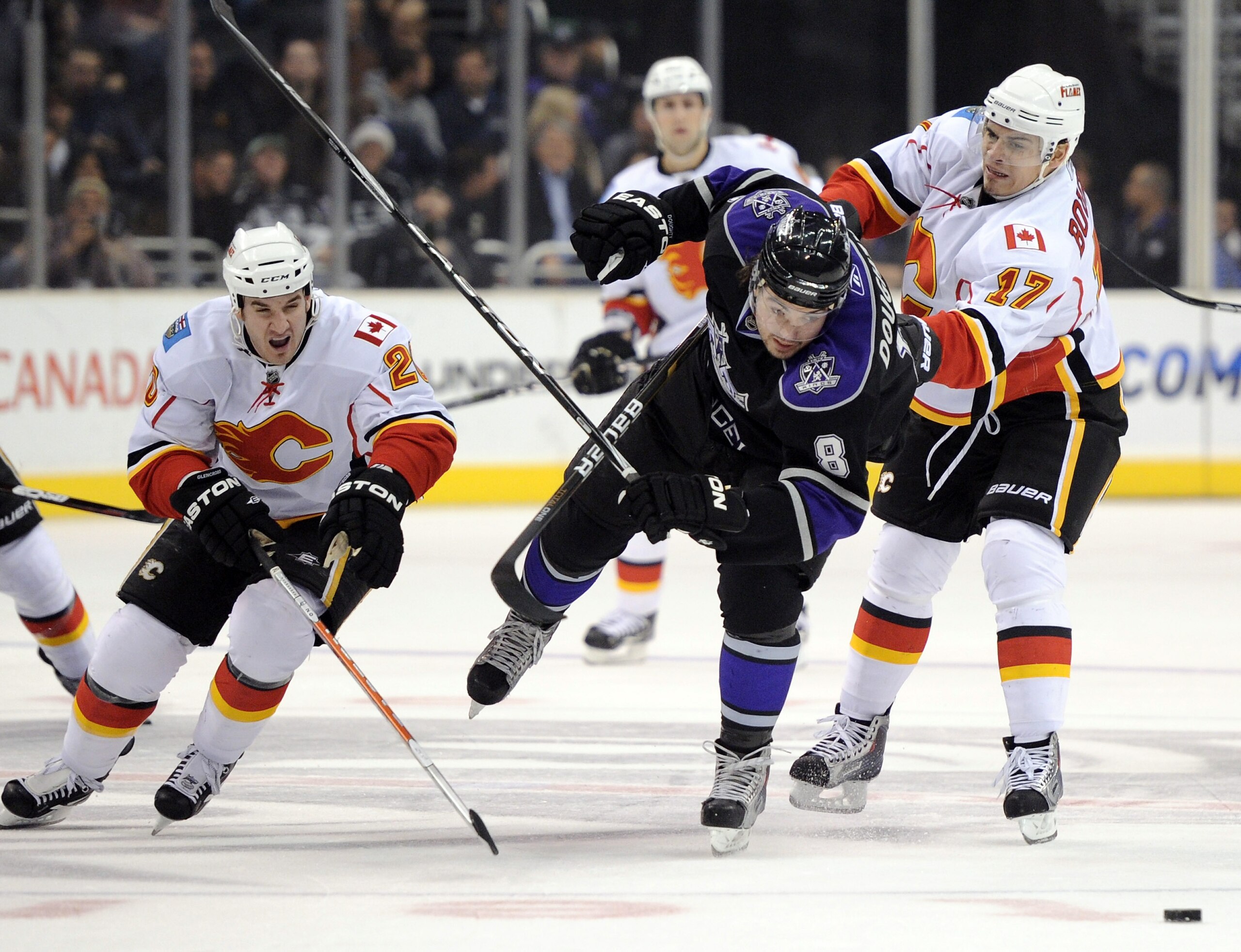 LOS ANGELES, CA - DECEMBER 09:  Drew Doughty #8 of the Los Angeles Kings is checkedclosely by Curtis Glencross #20 and  Rene Bourque #17 of the Calgary Flames at the Staples Center on December 9, 2010 in Los Angeles, California.  (Photo by Harry How/Getty