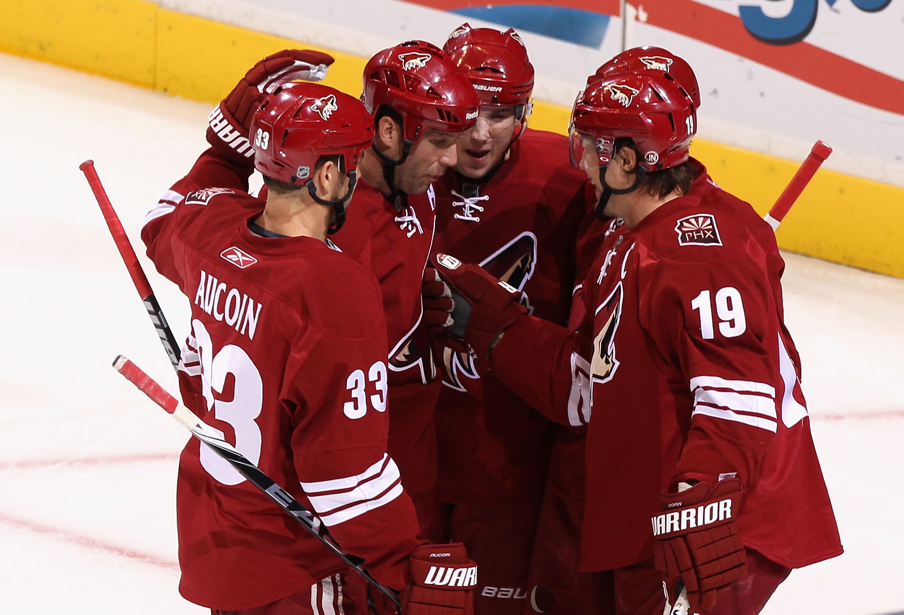 GLENDALE, AZ - DECEMBER 11:  Shane Doan #19 (R) of the Phoenix Coyotes celebrates with teammates Adrian Aucoin #33, Ed Jovanovski #55 and Scottie Upshall #8 after Doan scored a first period goal against the Dallas Stars during the NHL game at Jobing.com A