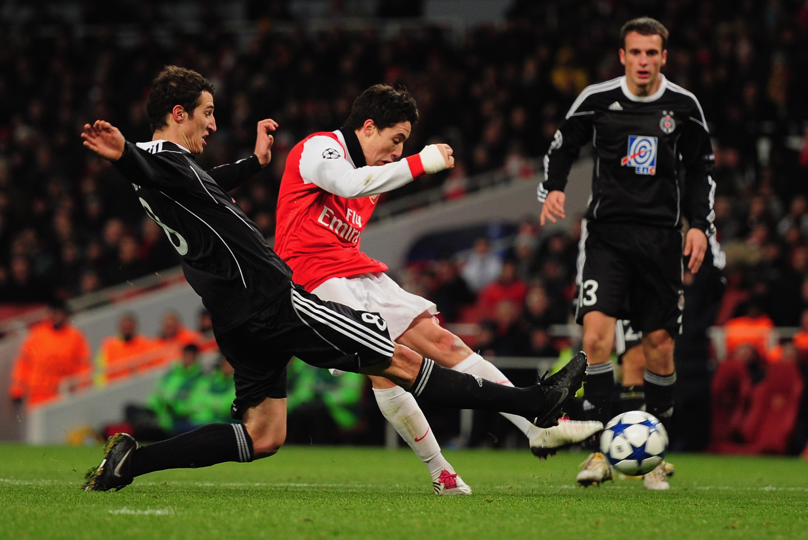 LONDON, ENGLAND - DECEMBER 08:  Samir Nasri of Arsenal shoots past Radosav Petrovic of FK Partizan Belgrade to score their thrid goal during theUEFA Champions League Group H match between Arsenal and FK Partizan Belgrade at the Emirates Stadium on Decembe