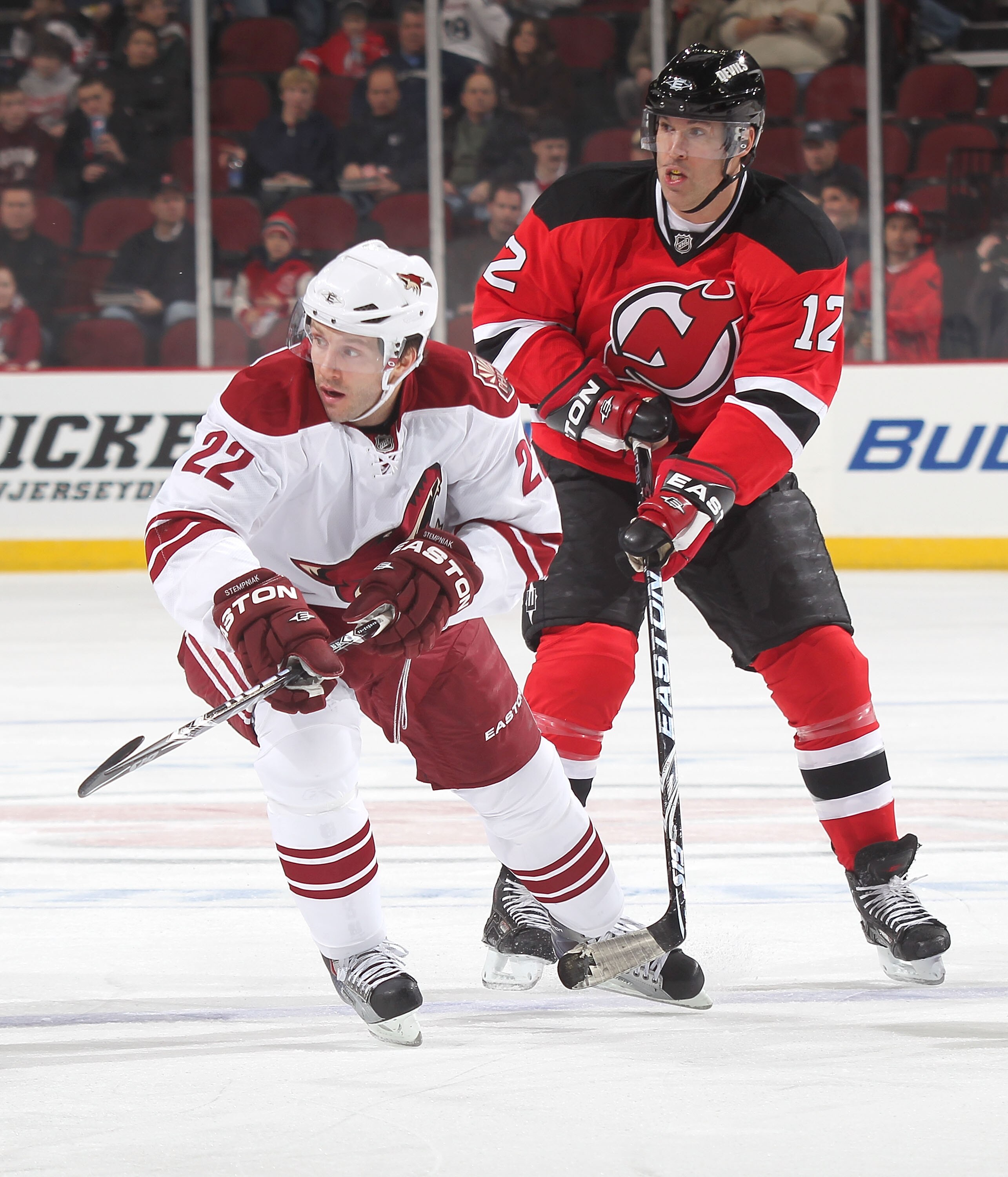NEWARK, NJ - DECEMBER 15:  Lee Stempniak #22 of the Phoenix Coyotes is covered by Brian Rolston #12 of the New Jersey Devils during the first period of a hockey game at the Prudential Center on December 15, 2010 in Newark, New Jersey.  (Photo by Paul Bere