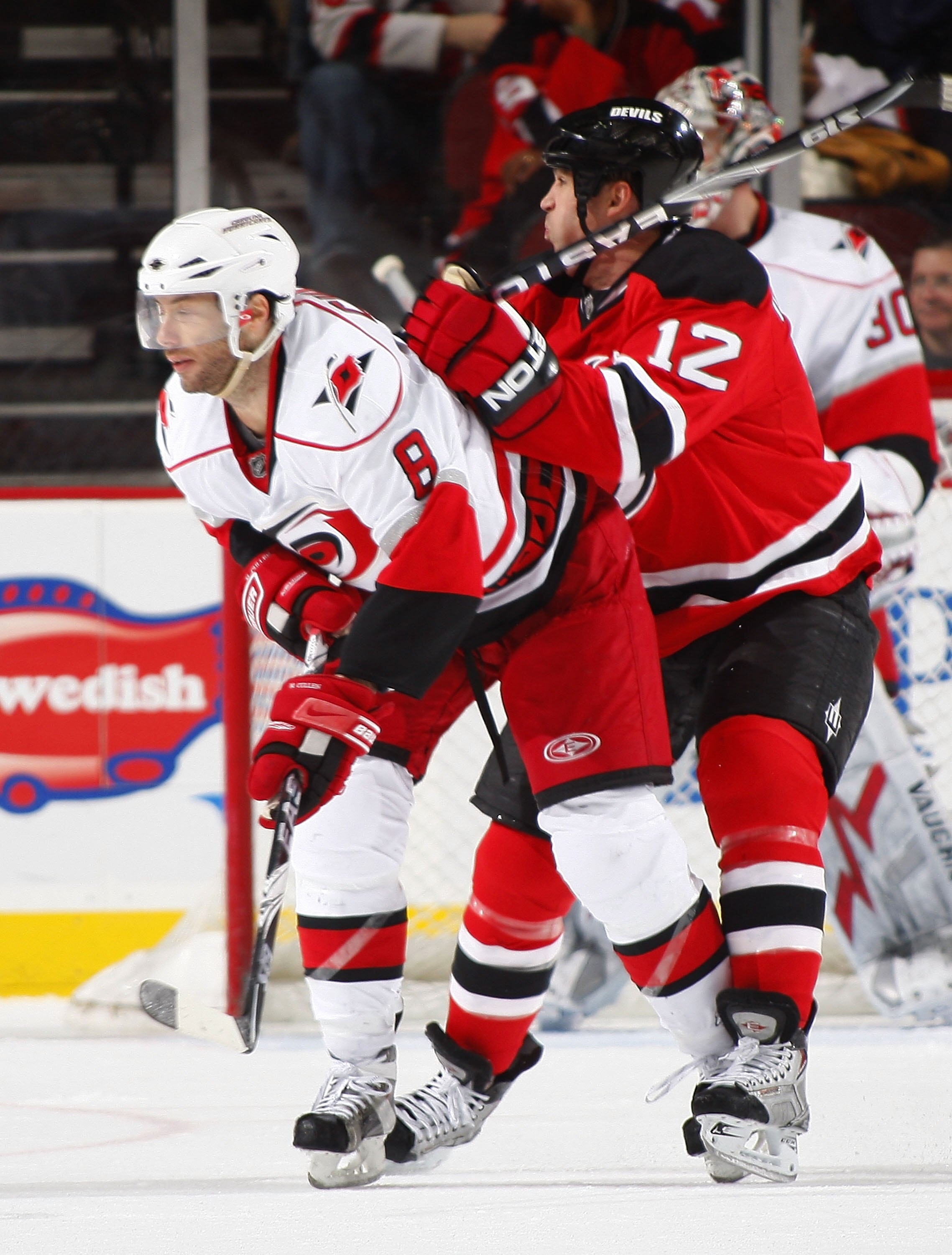 NEWARK, NJ - DECEMBER 09:  Matt Cullin #8 of the Carolina Hurricanes is checked by Brian Rolston #12 of the New Jersey Devils on December 9, 2009 in Newark, New Jersey.  (Photo by Paul Bereswill/Getty Images)