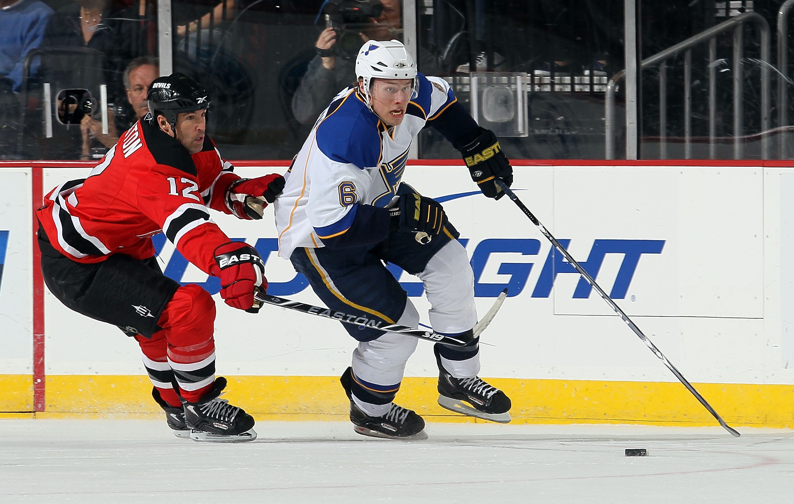 NEWARK, NJ - MARCH 20:  Erik Johnson #6 of the St. Louis Blues skates with the puck past Brian Rolston #12 of the New Jersey Devils at the Prudential Center on March 20, 2010 in Newark, New Jersey.  (Photo by Jim McIsaac/Getty Images)