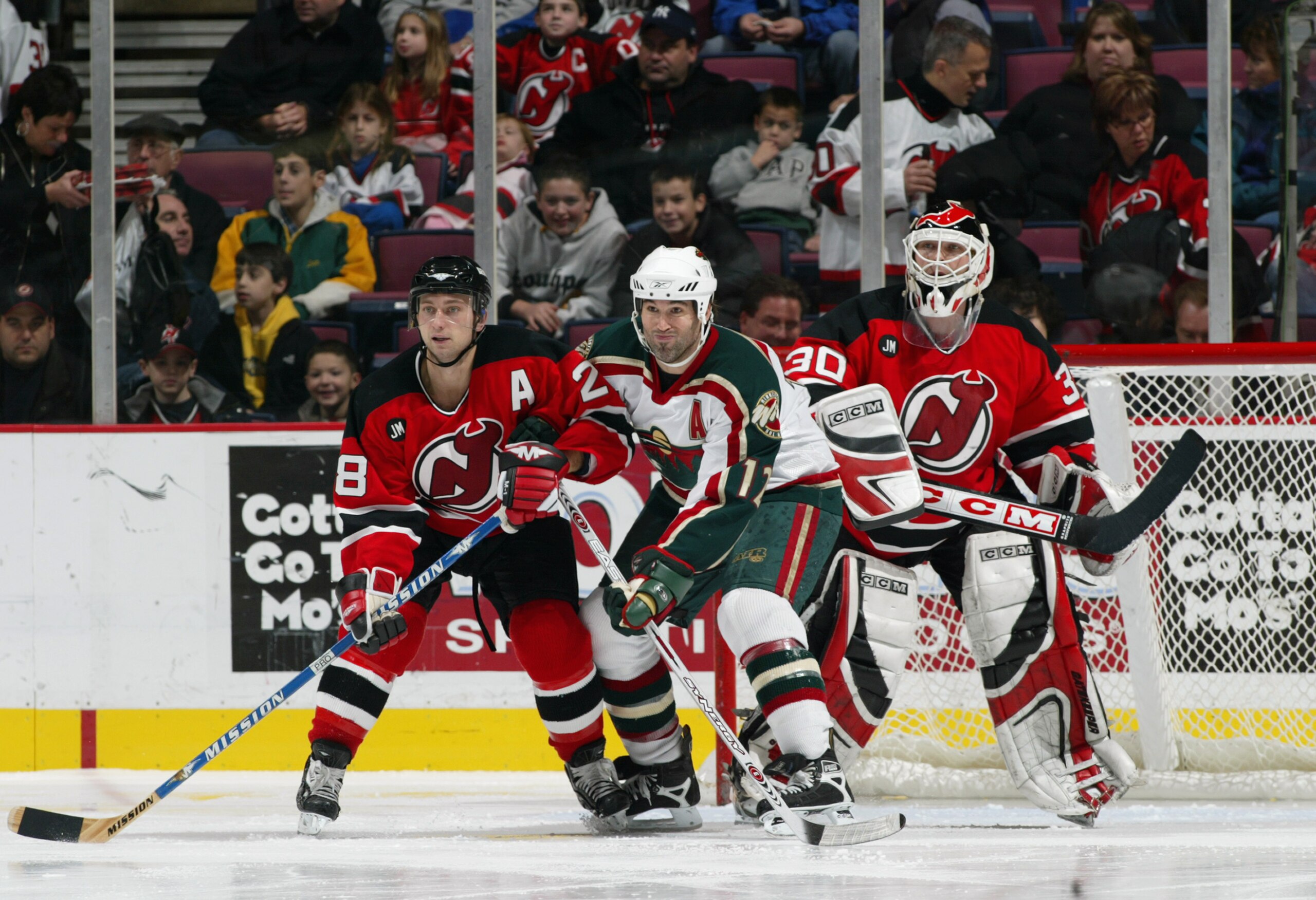 EAST RUTHERFORD, NJ - DECEMBER 3:  Brian Rafalski #28 of the New Jersey Devils vies for position with Brian Rolston #12 of the Minnesota Wild in the crease in front of goaltender Martin Brodeur #30 of the New Jersey Devils during their NHL game at Contine