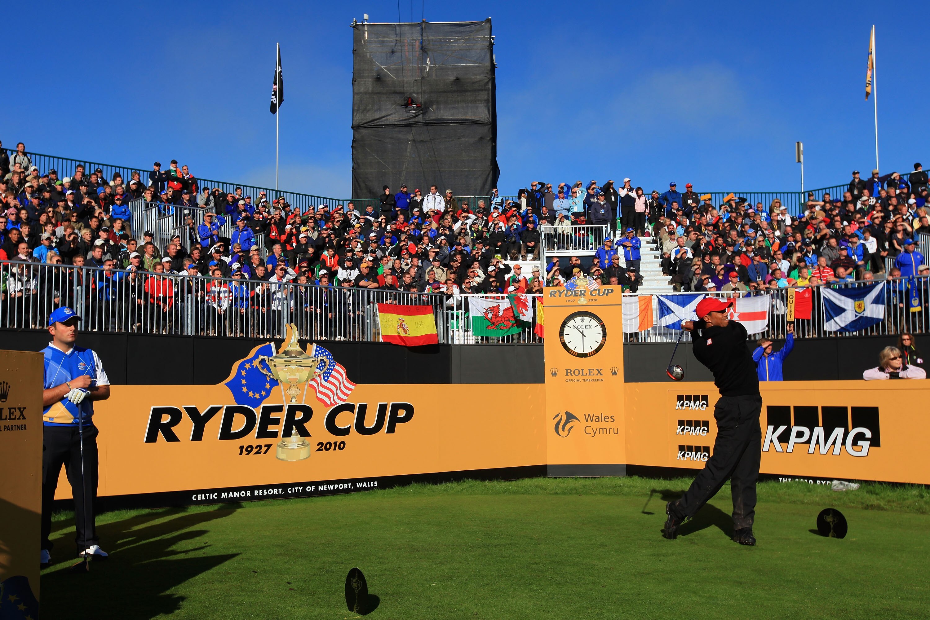 NEWPORT, WALES - OCTOBER 04:  Tiger Woods of the USA hits his tee shot on the first hole as Francesco Molinari of Europe looks on in the singles matches during the 2010 Ryder Cup at the Celtic Manor Resort on October 4, 2010 in Newport, Wales.  (Photo by 