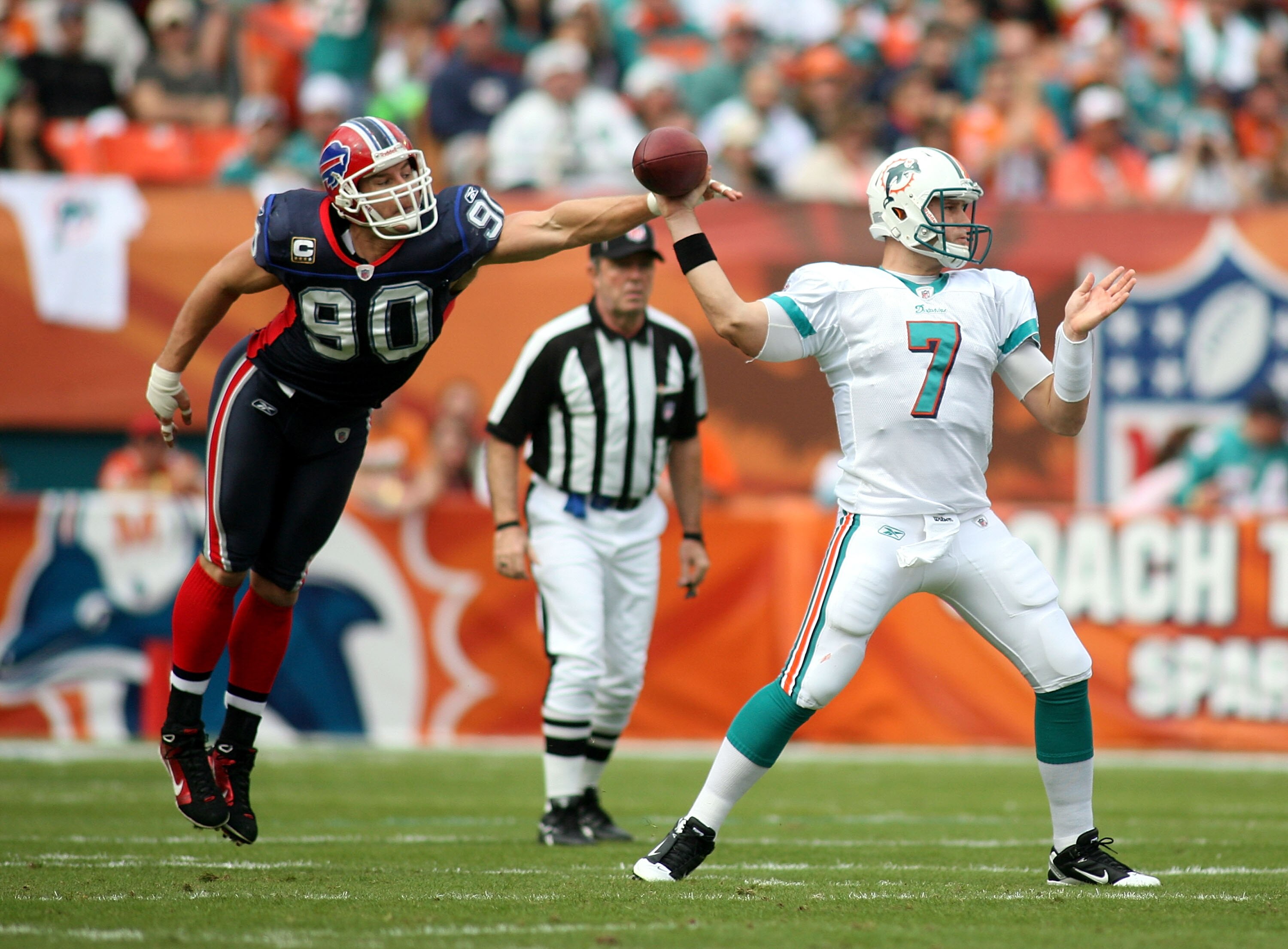 MIAMI, FL - DECEMBER 19:  Quarterback Chad Henne #7 of the Miami Dolphins is pressured by Linebacker Chris Kelsay #90 of the Buffalo Bills during a game at Sun Life Stadium on December 19, 2010 in Miami, Florida. The Bills defeated the Dolphins 17-14.  (P