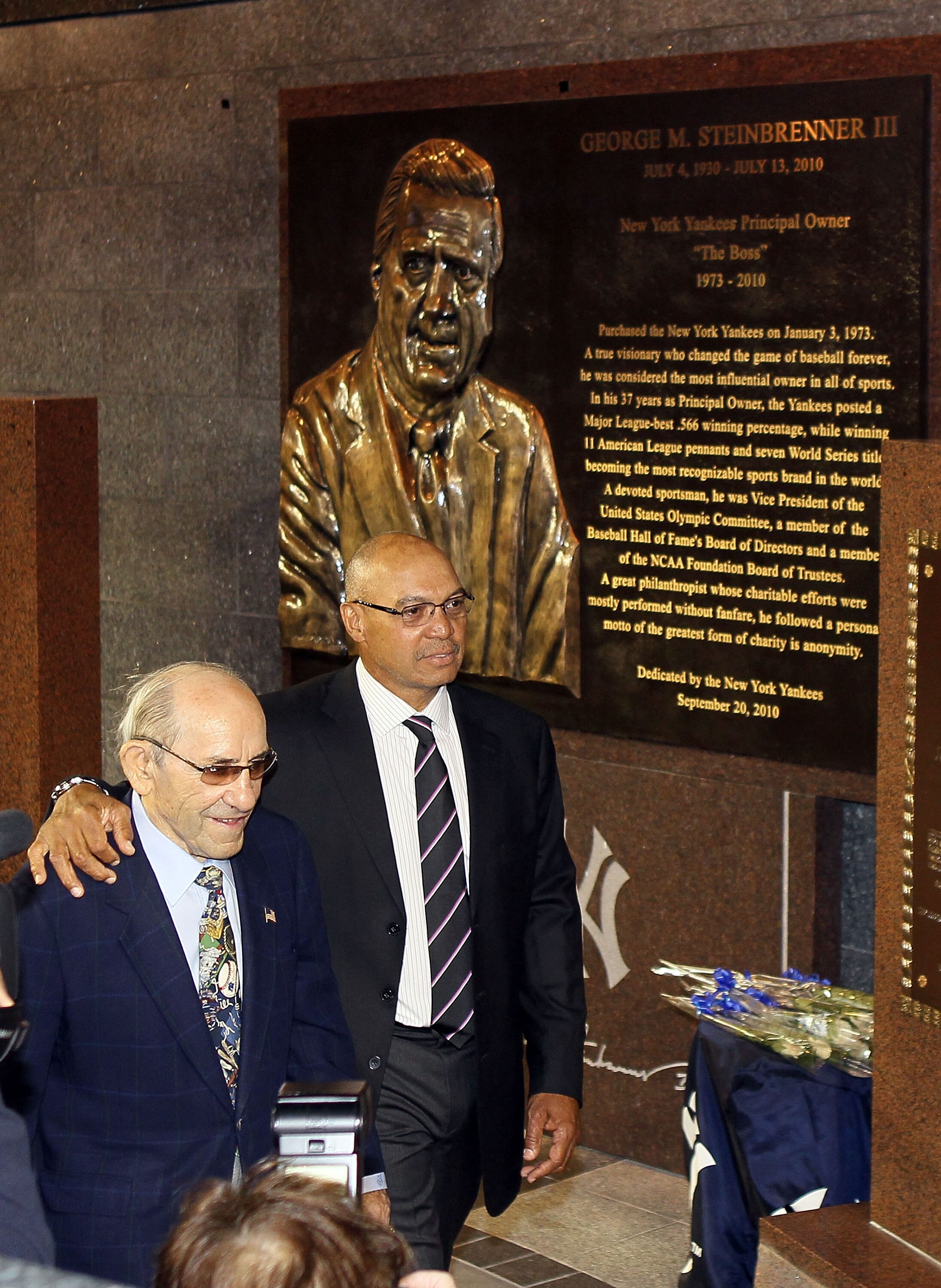 NEW YORK - SEPTEMBER 20:  New York Yankees Hall of Famers Yogi Berra (L) and Reggie Jackson walk past the monument to the late owner George Steinbrenner prior to a game against the Tampa Bay Rays on September 20, 2010 at Yankee Stadium in the Bronx boroug