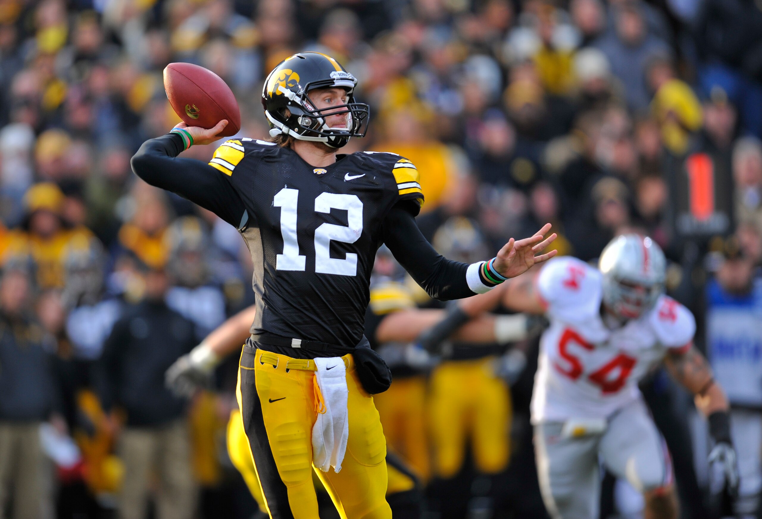 IOWA CITY, IA - NOVEMBER 20:  Quarterback Ricky Stanzi #12 of the University of Iowa Hawkeyes throws under pressure from Ohio State Buckeyes defenders during the first half of play at Kinnick Stadium on November 20, 2010 in Iowa City, Iowa. Ohio State won
