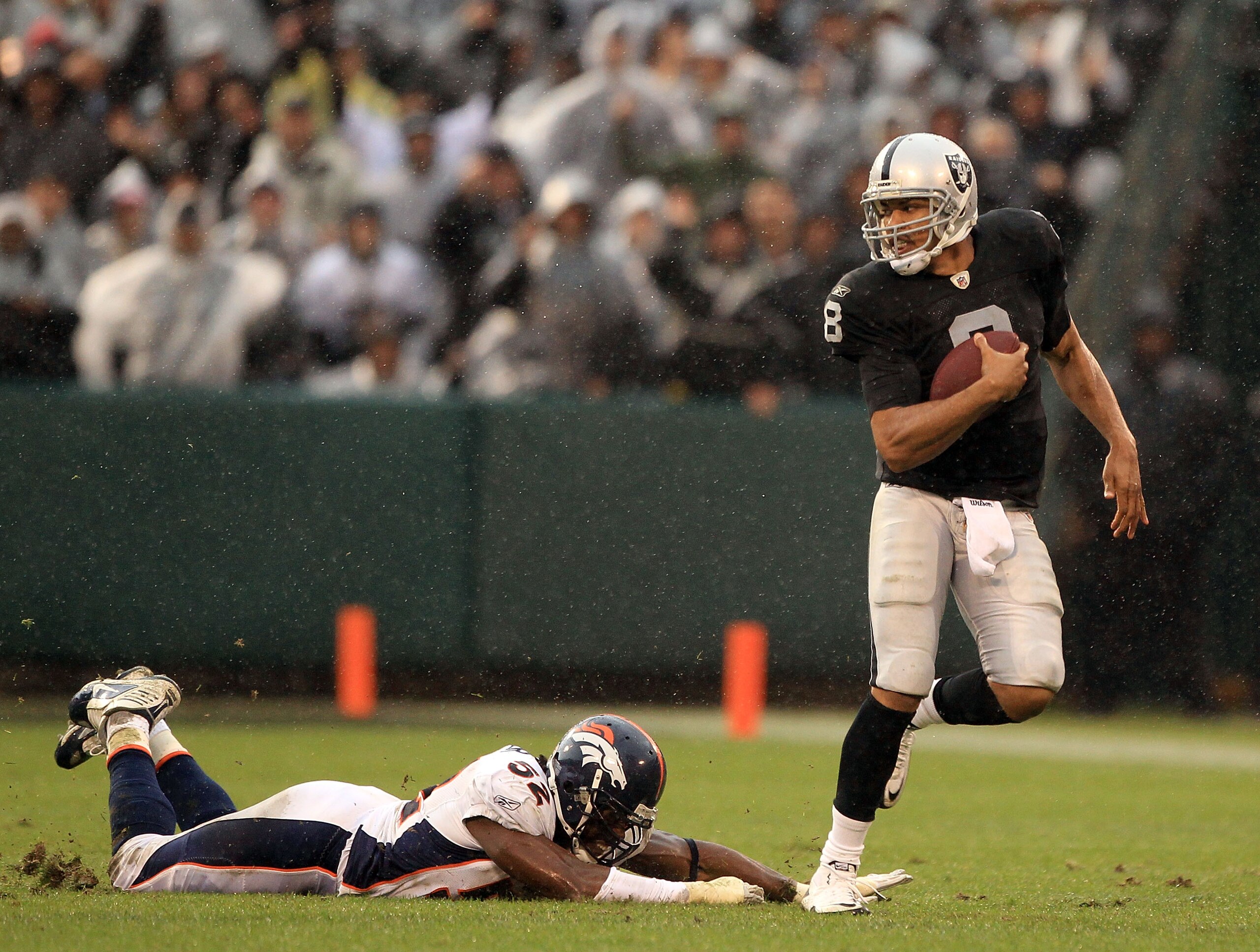 OAKLAND, CA - DECEMBER 19:  Jason Campbell #8 of the Oakland Raiders escapes a diving Jason Hunter #52 of the Denver Broncos at Oakland-Alameda County Coliseum on December 19, 2010 in Oakland, California.  (Photo by Ezra Shaw/Getty Images)