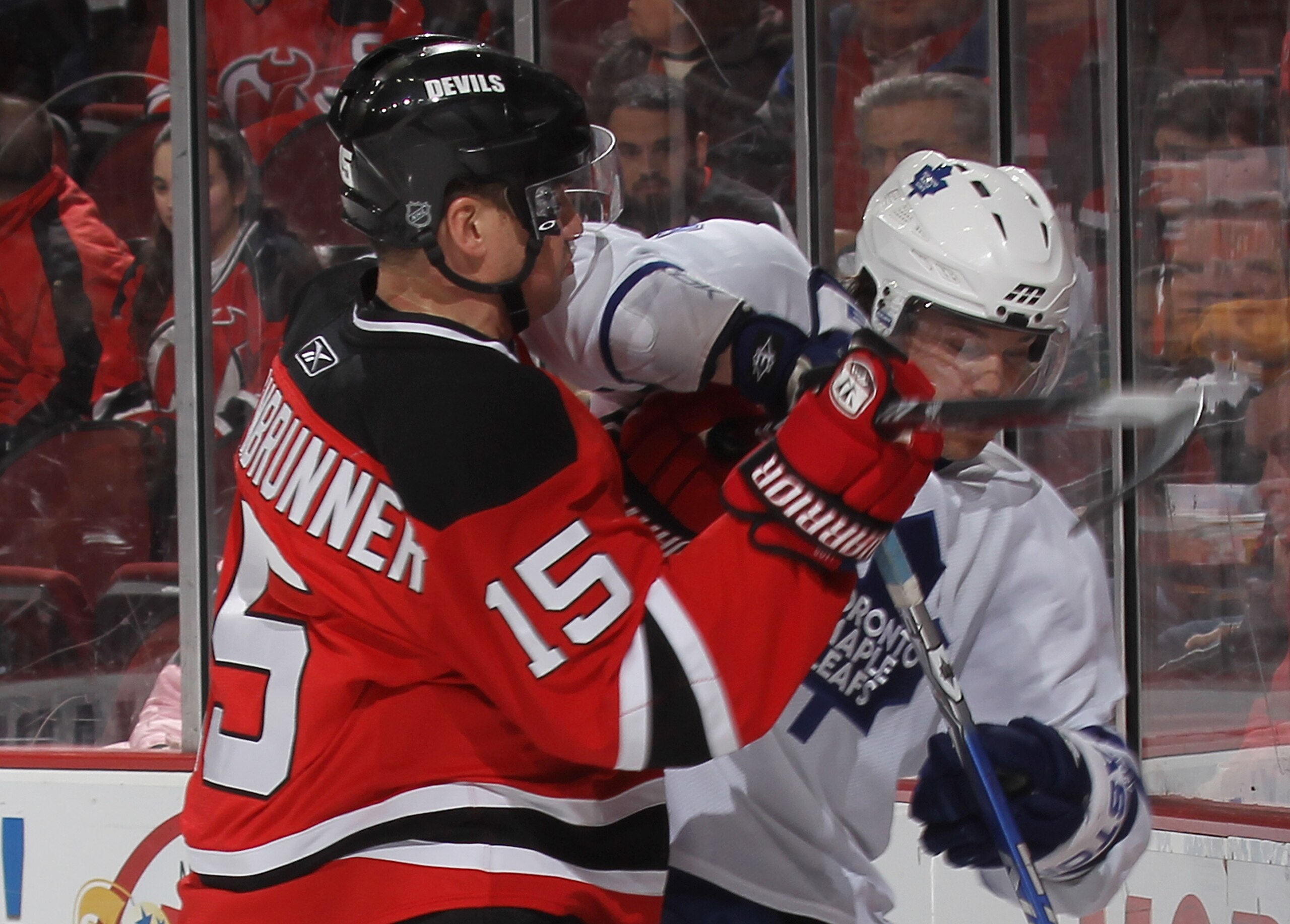NEWARK, NJ - JANUARY 29: Garnet Exelby #3 of the Toronto Maple Leafs is high-sticked by Jamie Langenbrunner #15 of the New Jersey Devils at the Prudential Center on January 29, 2010 in Newark, New Jersey. The Devils defeated the Maple Leafs 5-4 in overtim
