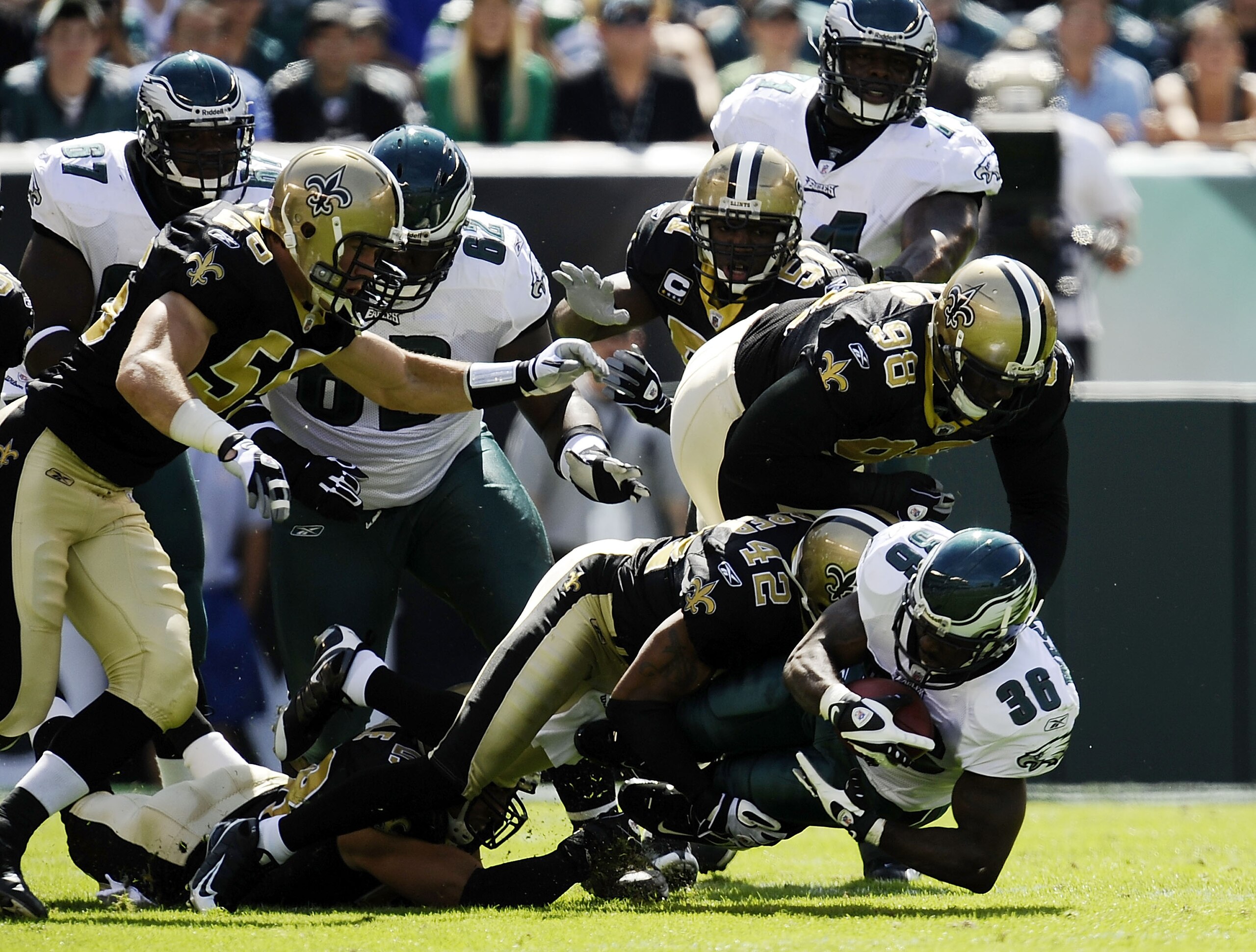 PHILADELPHIA - SEPTEMBER 20: Brian Westbrook #36 of the Philadelphia Eagles is tackled by Darren Sharper #42 and Sedrick Ellis #98 of the New Orleans Saints during their game at Lincoln Financial Field on September 20, 2009 in Philadelphia, Pennsylvania.