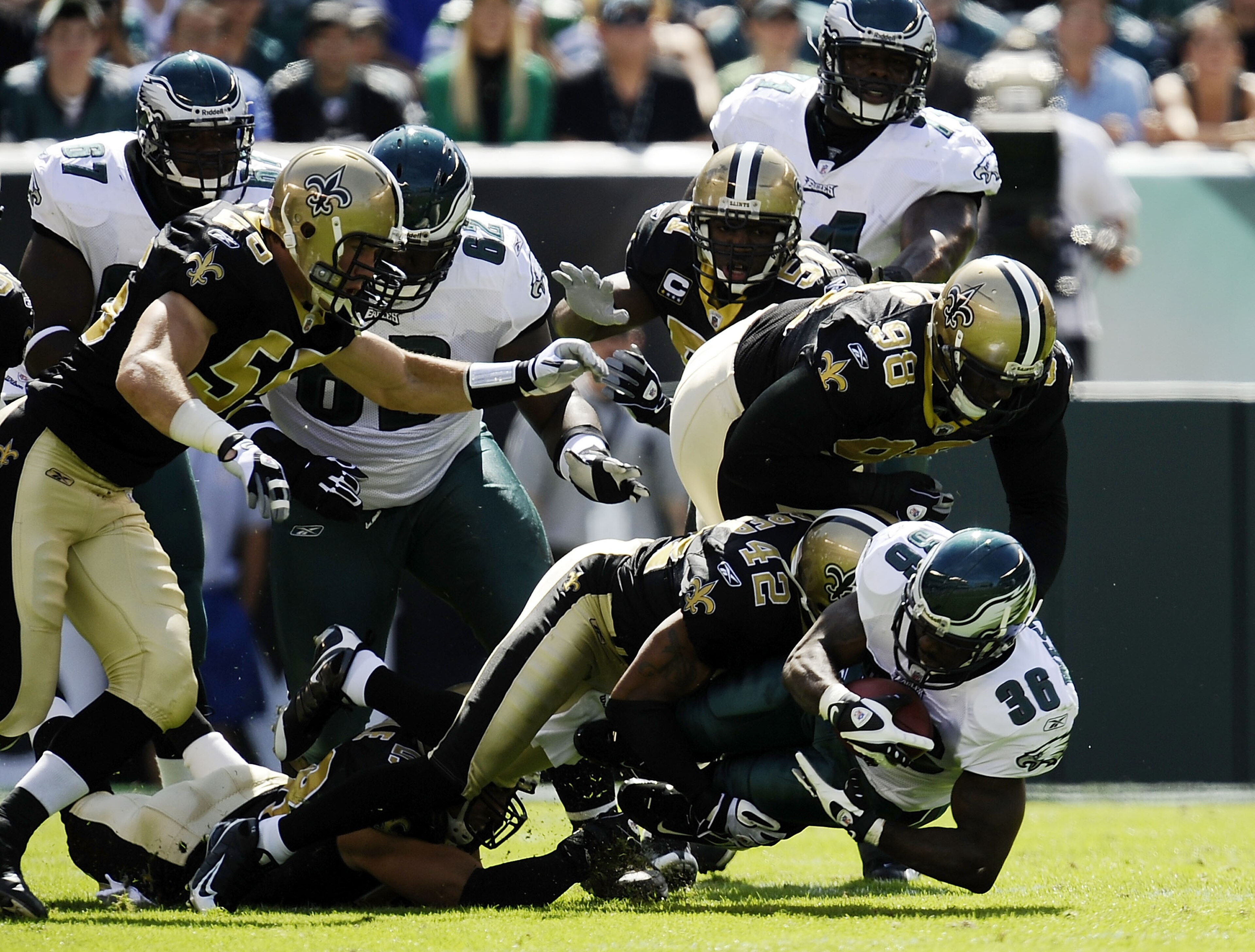 PHILADELPHIA - SEPTEMBER 20: Brian Westbrook #36 of the Philadelphia Eagles is tackled by Darren Sharper #42 and Sedrick Ellis #98 of the New Orleans Saints during their game at Lincoln Financial Field on September 20, 2009 in Philadelphia, Pennsylvania.