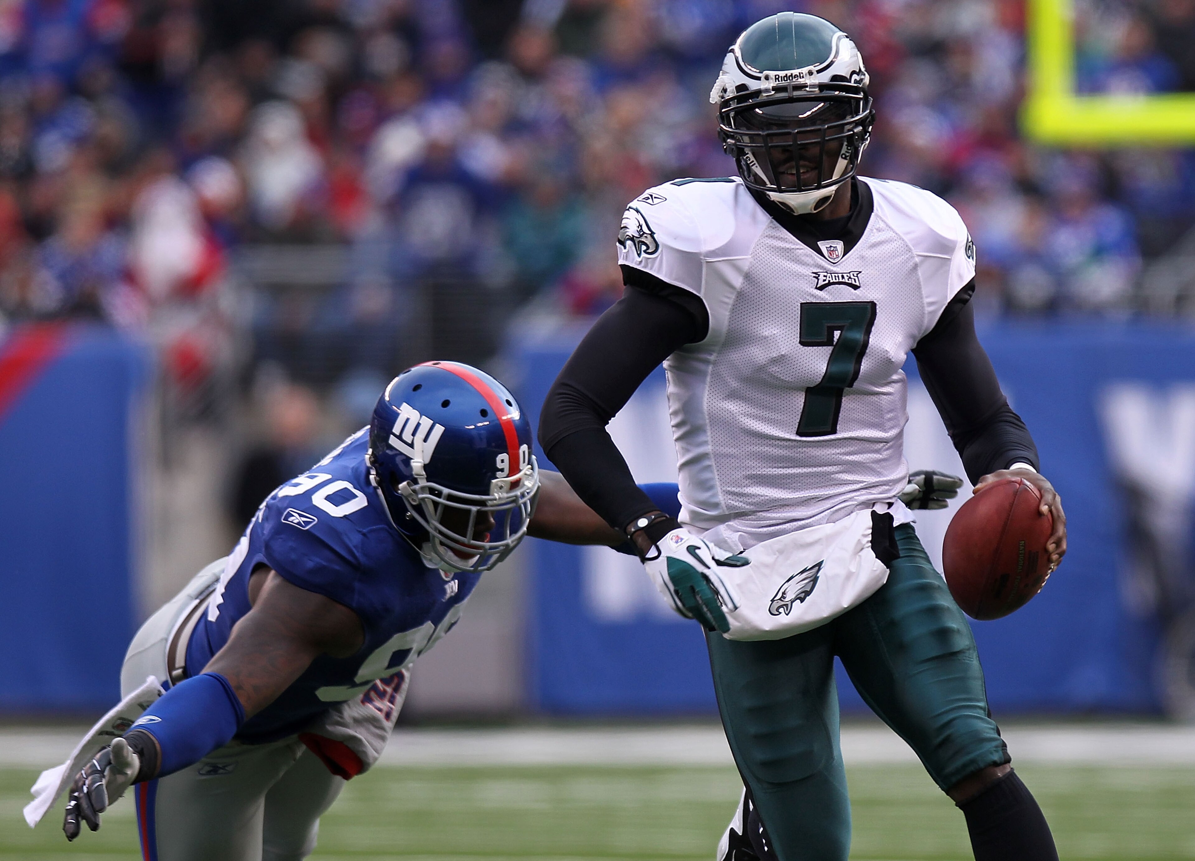 EAST RUTHERFORD, NJ - DECEMBER 19:  Michael Vick #7 of the Philadelphia Eagles rushes past the tackle attempt of Jason Pierre-Paul #90 of the New York Giants at New Meadowlands Stadium on December 19, 2010 in East Rutherford, New Jersey.  (Photo by Nick L