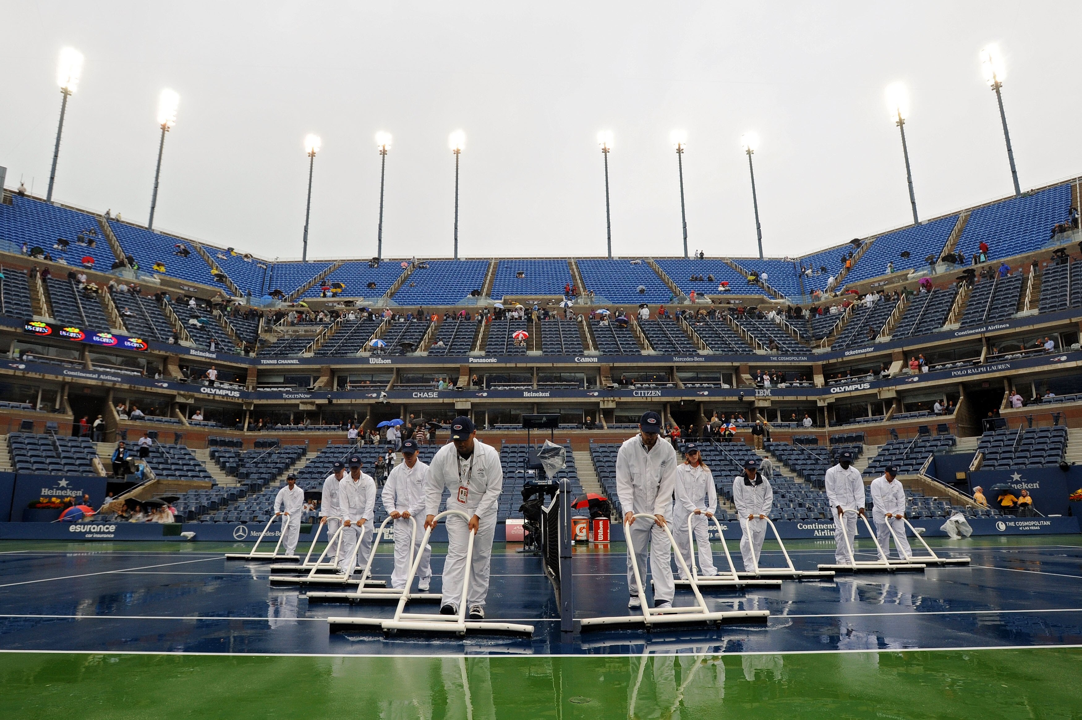 NEW YORK - SEPTEMBER 12:  Ground crew workers try to dry the court during a rain delay on day fourteen of the 2010 U.S. Open at the USTA Billie Jean King National Tennis Center on September 12, 2010 in the Flushing neighborhood of the Queens borough of Ne
