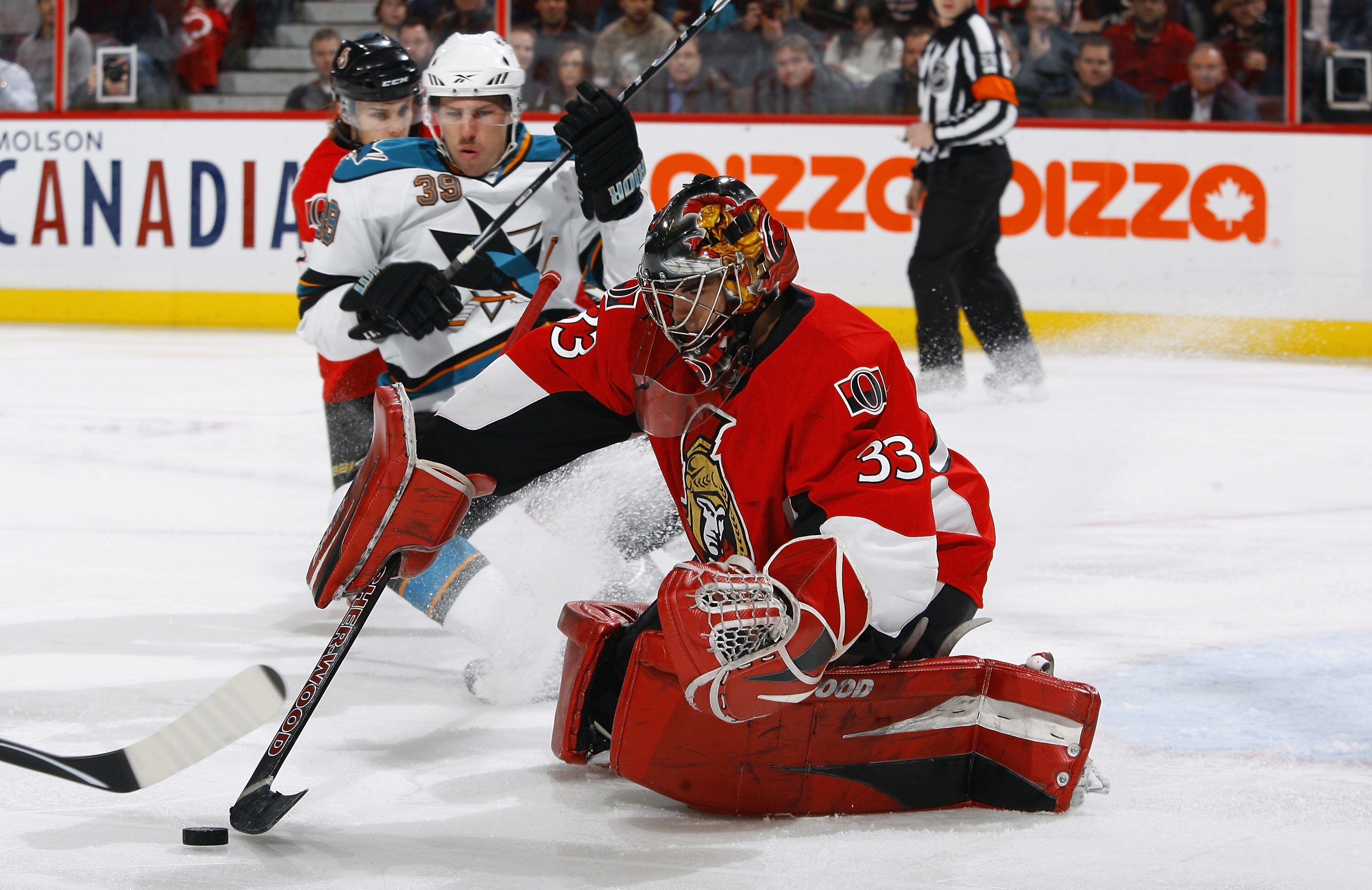 OTTAWA, ON - DECEMBER 02:  Pascal Leclaire #33 of the Ottawa Senators tries to control a rebound while Logan Couture #39 of the San Jose Sharks skates hard into the crease in a game at Scotiabank Place on December 2, 2010 in Ottawa, Ontario, Canada.  (Pho