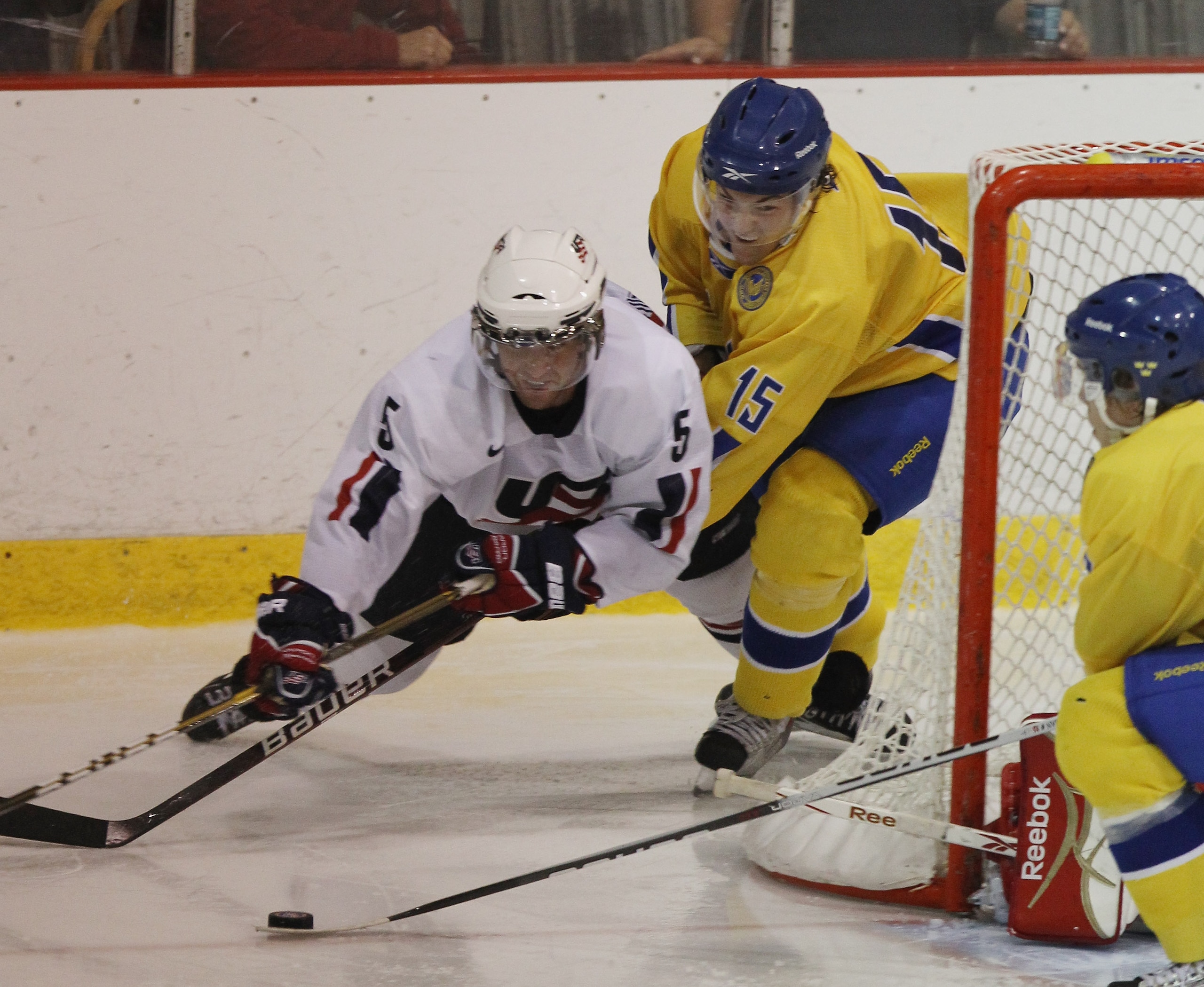 LAKE PLACID, NY - AUGUST 03: Simon Bertilsson #15  of Team Sweden trips up Kyle Palmieri #5 of Team USA at the USA Hockey National Evaluation Camp game on August 3, 2010 in Lake Placid, New York.  The USA defeated Sweden 6-3. (Photo by Bruce Bennett/Getty