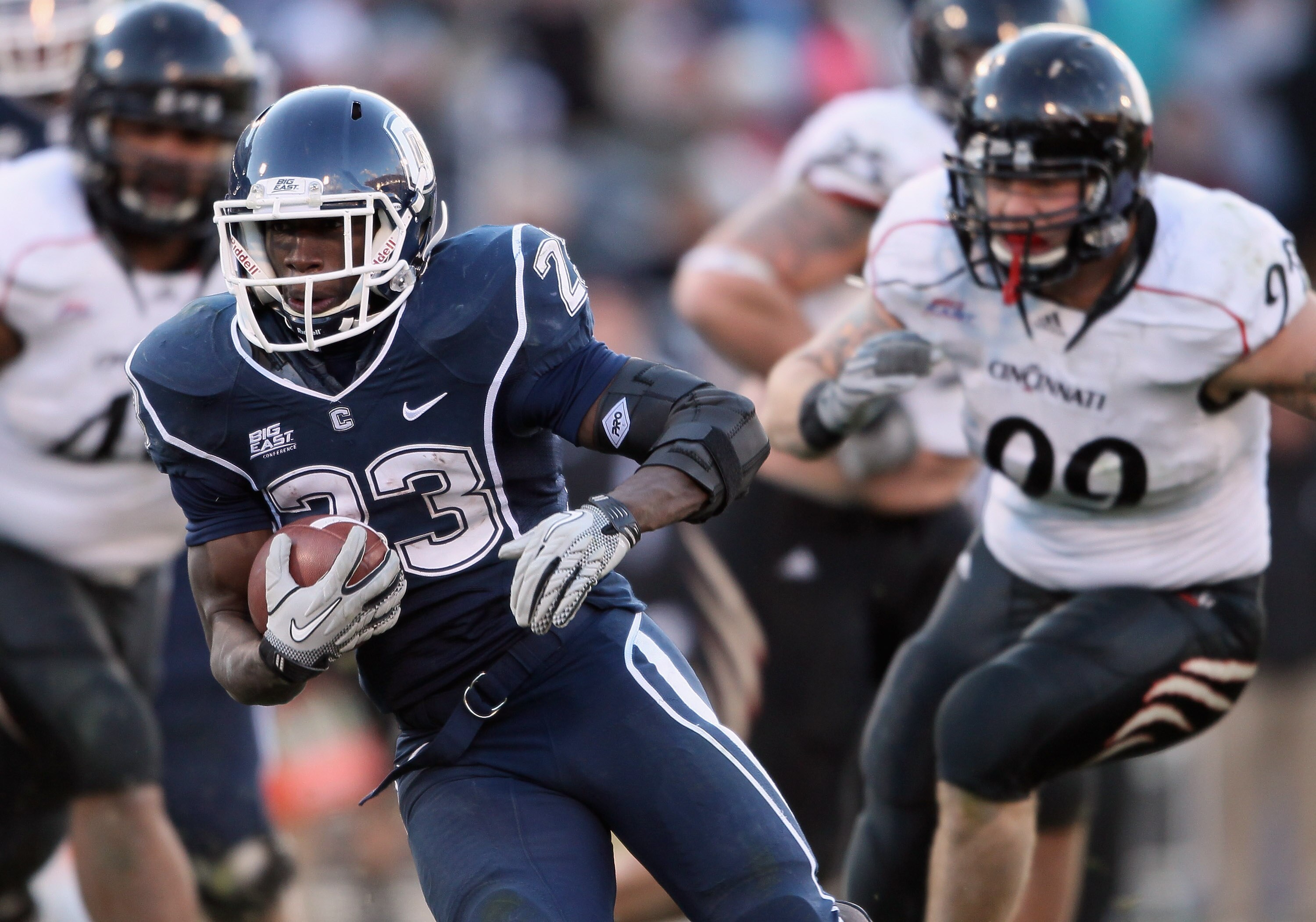 EAST HARTFORD, CT - NOVEMBER 27:  Jordan Todman #23 of the Connecticut Huskies carries the ball past the Cincinnati Bearcats defense on November 27, 2010 at Rentschler Field in East Hartford, Connecticut. The Huskies defeated the Bearcats 38-17.  (Photo b