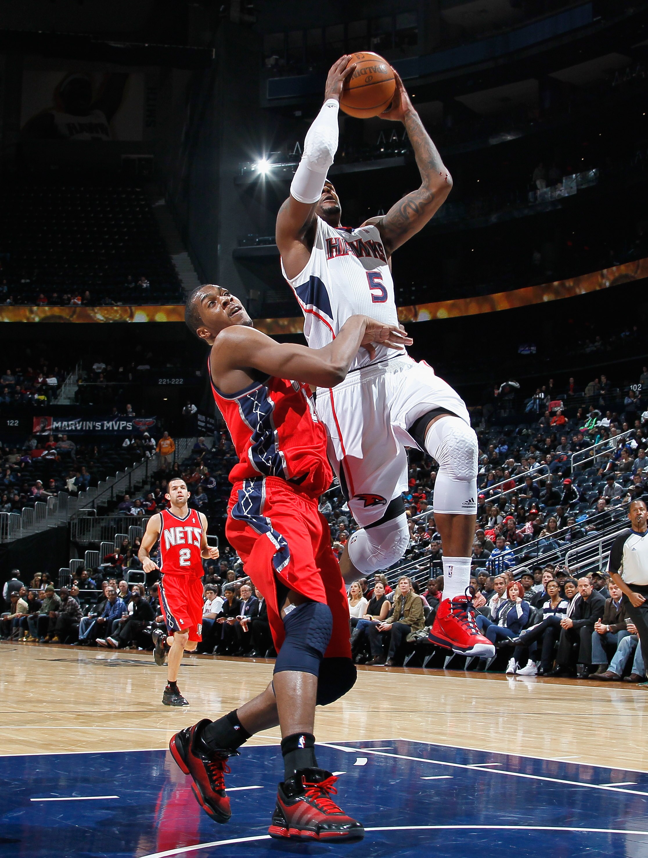 ATLANTA, GA - DECEMBER 07:  Derrick Favors #14 of the New Jersey Nets fouls Josh Smith #5 of the Atlanta Hawks at Philips Arena on December 7, 2010 in Atlanta, Georgia.  NOTE TO USER: User expressly acknowledges and agrees that, by downloading and/or usin