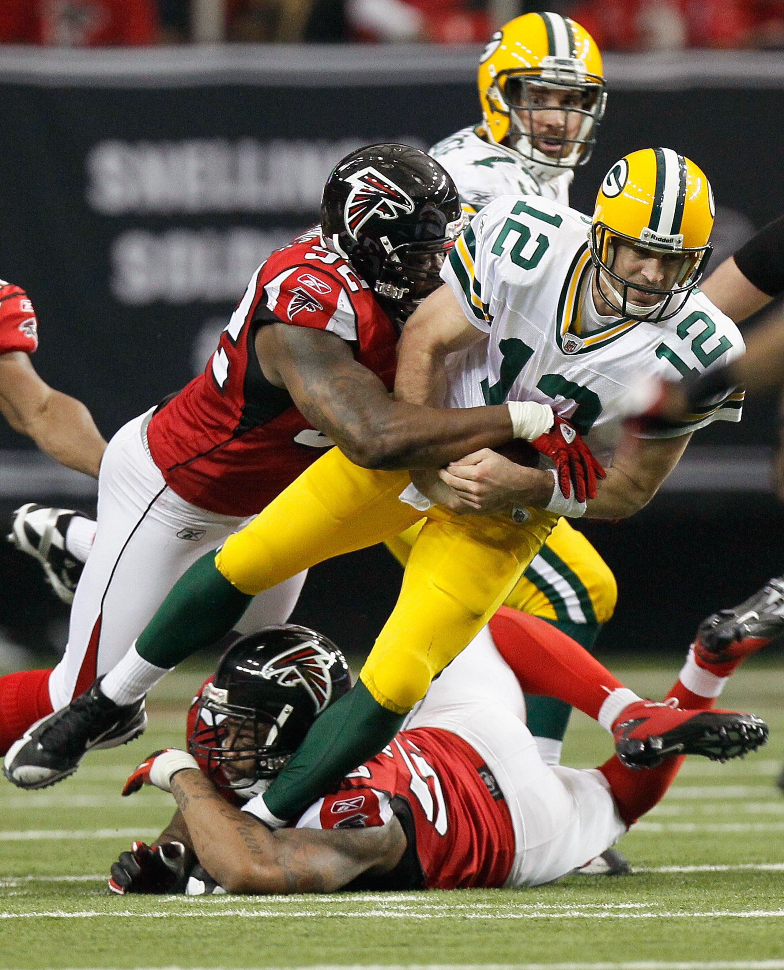 ATLANTA - NOVEMBER 28:  Chauncey Davis #92 and John Abraham #55 of the Atlanta Falcons sack quarterback Aaron Rodgers #12 of the Green Bay Packers at Georgia Dome on November 28, 2010 in Atlanta, Georgia.  (Photo by Kevin C. Cox/Getty Images)