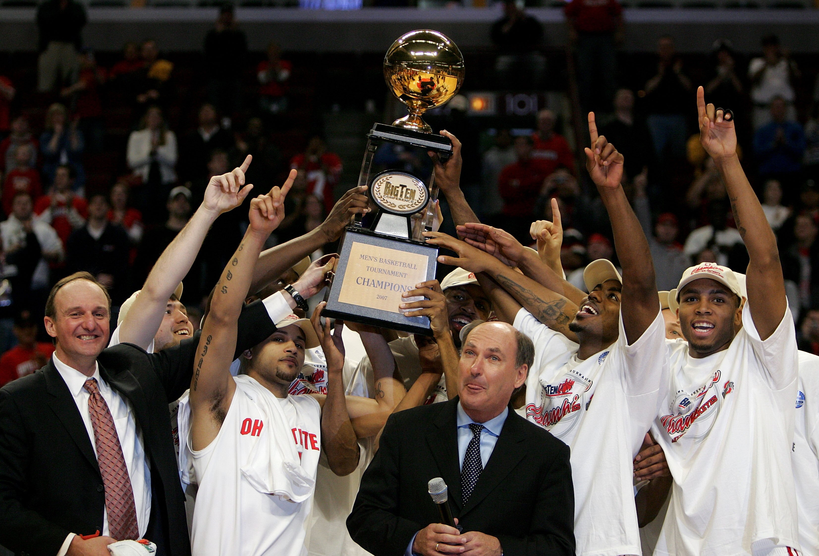 CHICAGO - MARCH 11:  The Ohio State Buckeyes celebrate as they are presented with the trophy by Big Ten Commissioner Jim Delany (C, w/microphone) following Ohio St.'s 66-49 win against the Wisconsin Badgers during the Final of the Big Ten Men's Basketball