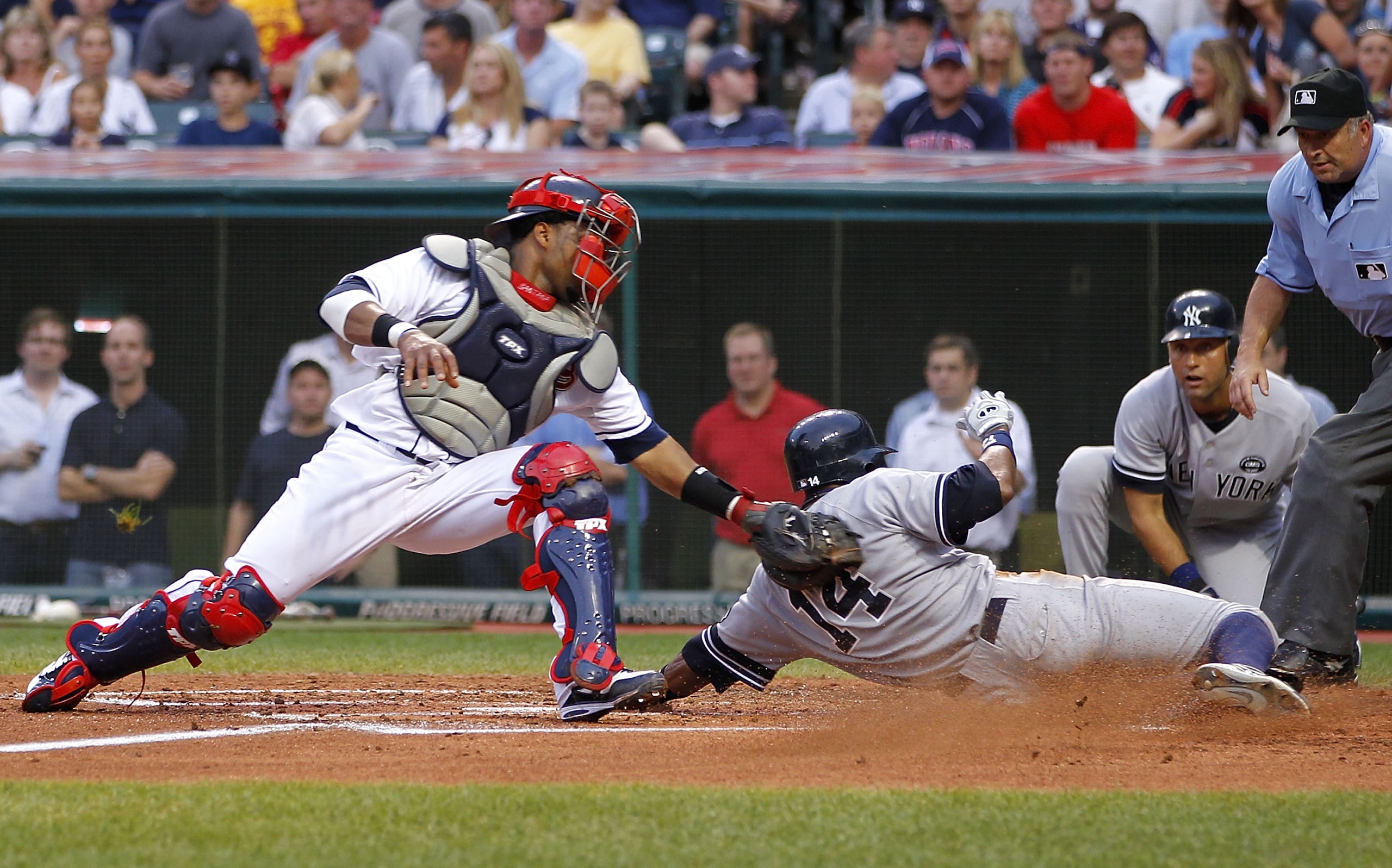 CLEVELAND - JULY 28: Curtis Granderson #14 of the New York Yankees beats the tag by Carlos Santana #41 of the Cleveland Indians to score a second inning run on July 28, 2010 at Progressive Field in Cleveland, Ohio.  (Photo by Gregory Shamus/Getty Images)
