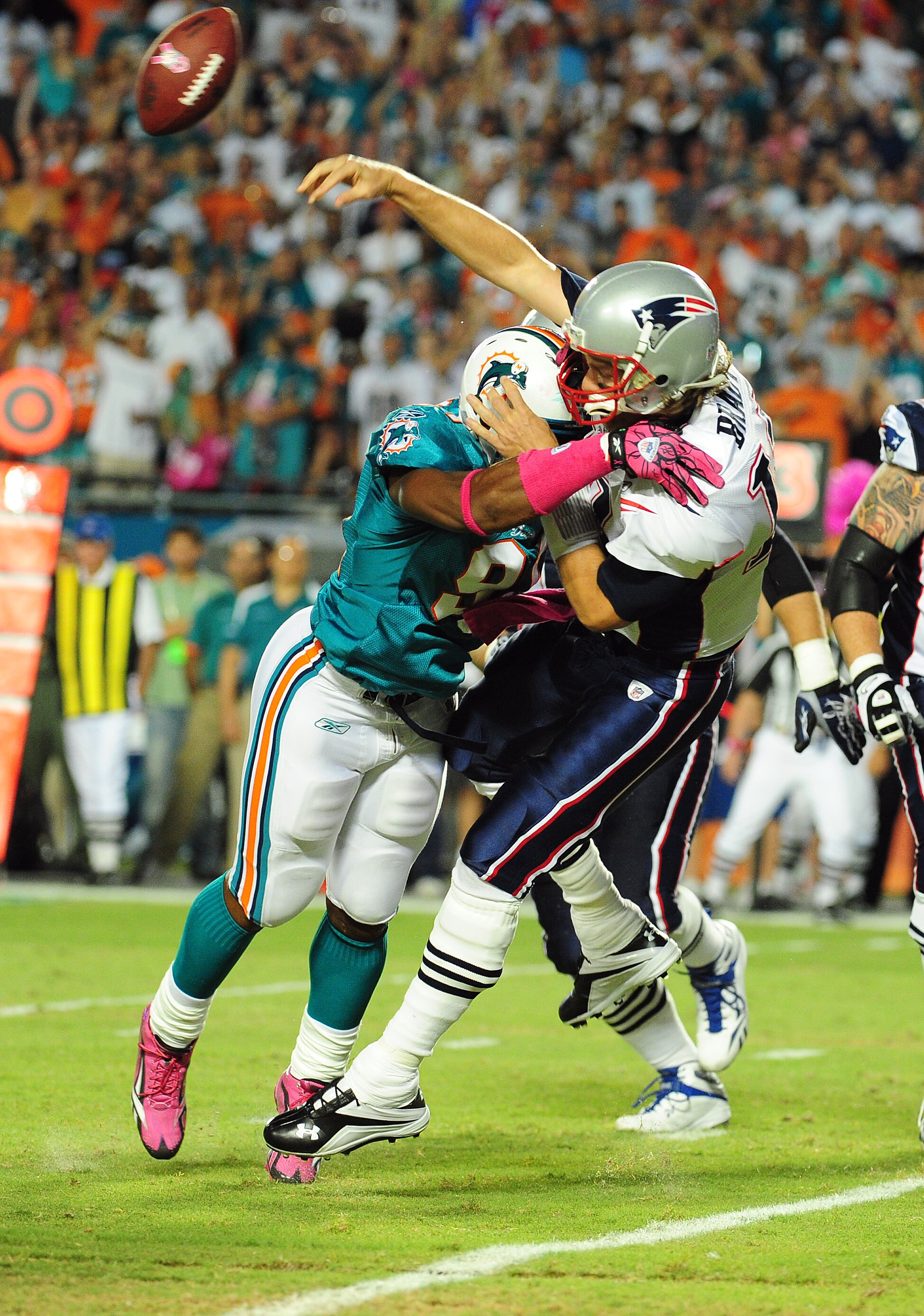 MIAMI - OCTOBER 4: Tom Brady #12 of the New England Patriots is hit as he passes by Cameron Wake #91 of the Miami Dolphins at Sun Life Field on October 4, 2010 in Miami, Florida. (Photo by Scott Cunningham/Getty Images)