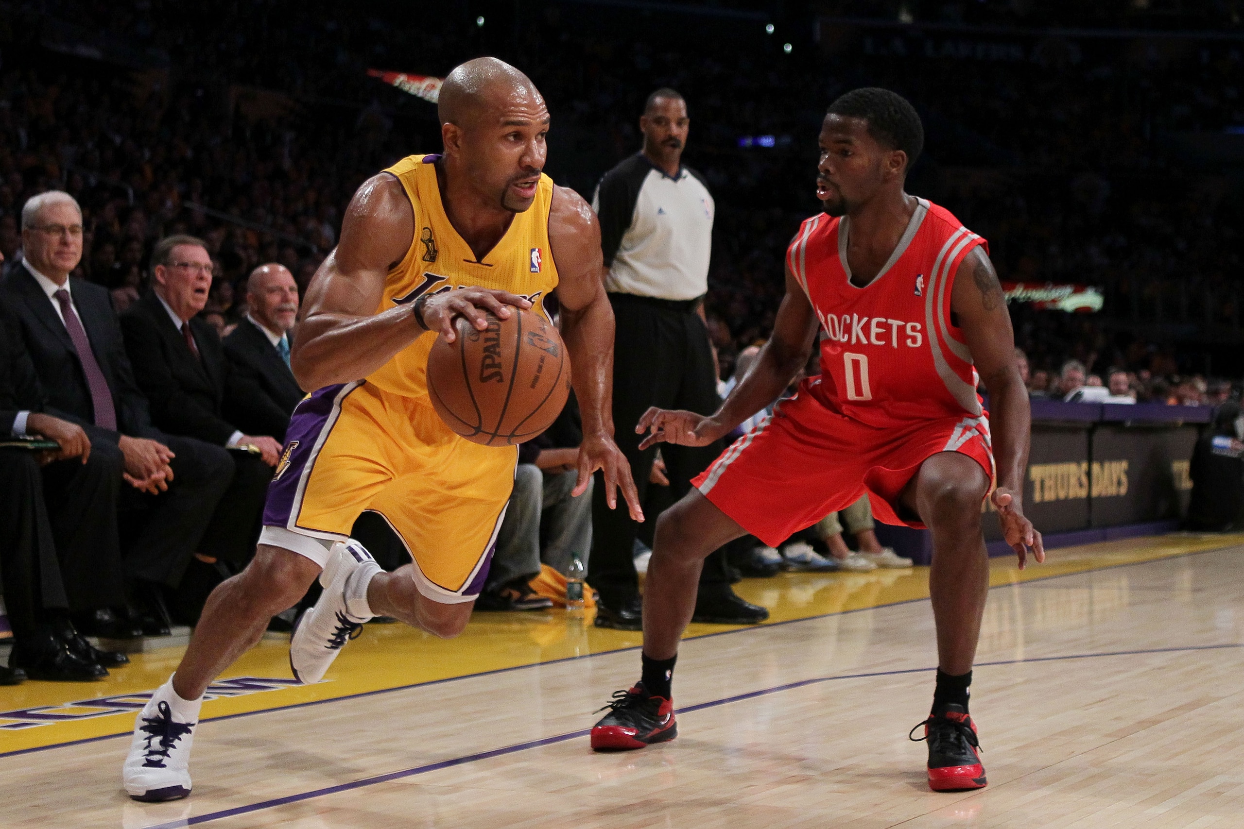 LOS ANGELES, CA - OCTOBER 26:  Derek Fisher #2 of the Los Angeles Lakers dribbles the ball against Aaron Brooks #0 of the Houston Rockets during their opening night game at Staples Center on October 26, 2010 in Los Angeles, California. NOTE TO USER: User