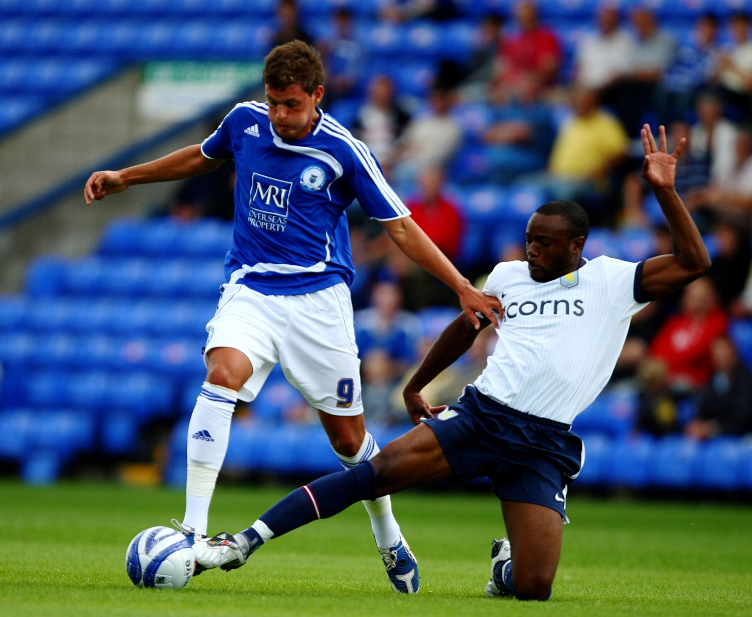 PETERBOROUGH, ENGLAND - JULY 18: Ben Wright (L) of Peterborough United holds off the challenge of Nigel Reo-Coker (R) of Aston Villa during the pre season friendly between Peterborough United and Aston Villa at the London Road Stadium on July 18, 2009 in 