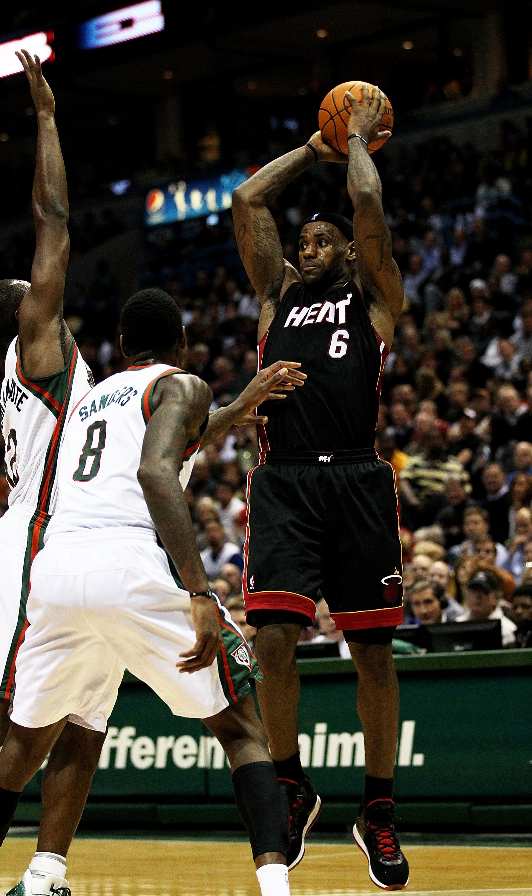 MILWAUKEE, WI - DECEMBER 06: LeBron James #6 of the Miami Heat leaps to pass over Corey Maggette #5 and Larry Sanders #8 of the Milwaukee Bucks at the Bradley Center on December 6, 2010 in Milwaukee, Wisconsin. The Heat defeated the Bucks 88-78. NOTE TO U