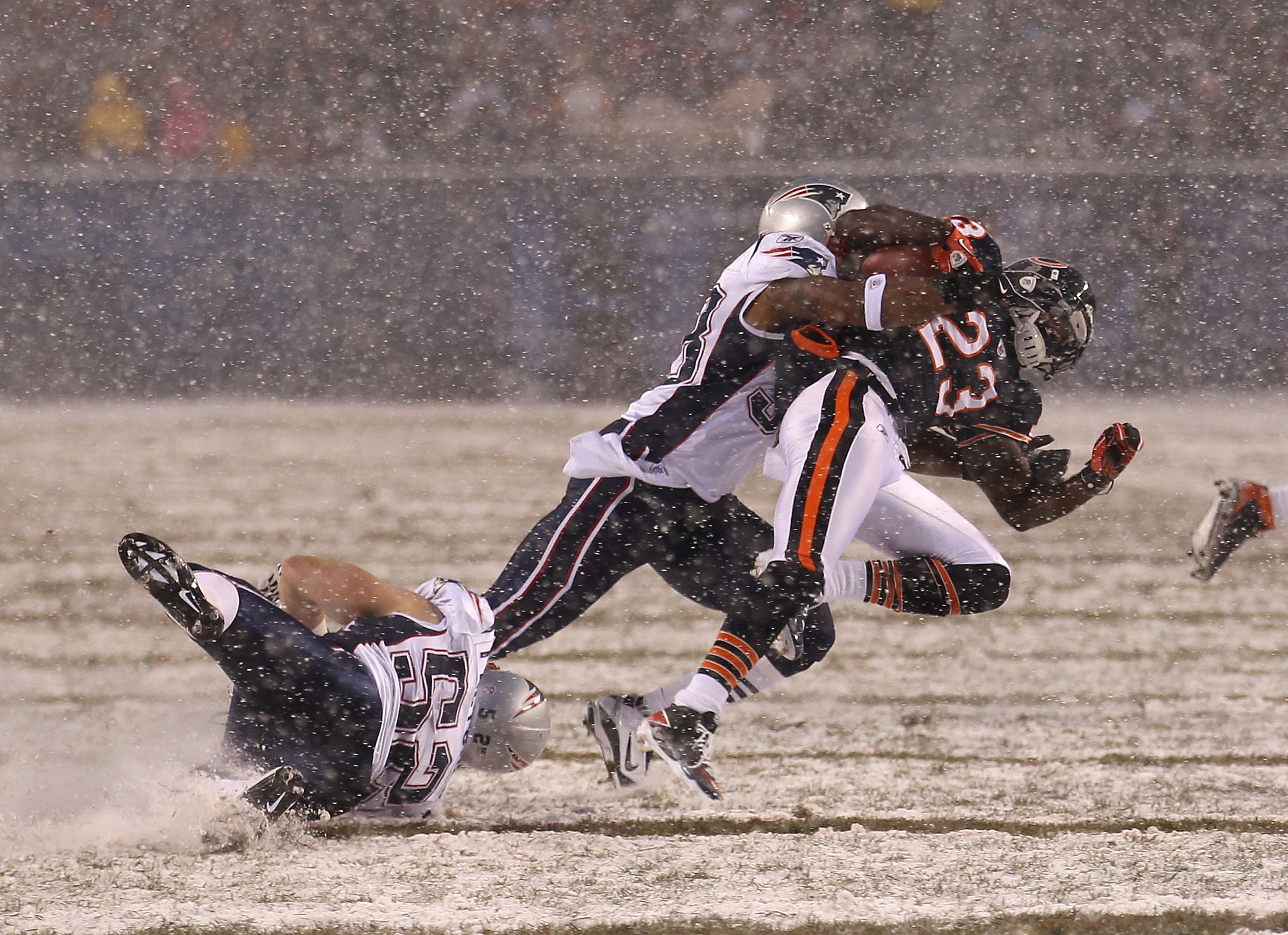 CHICAGO, IL - DECEMBER 12: Devin Hester #23 of the Chicago Bears is tackled by Sergio Brown #38 and Dane Fletcher #52 of the New England Patriots at Soldier Field on December 12, 2010 in Chicago, Illinois. The Patriots defeated the Bears 36-7. (Photo by J