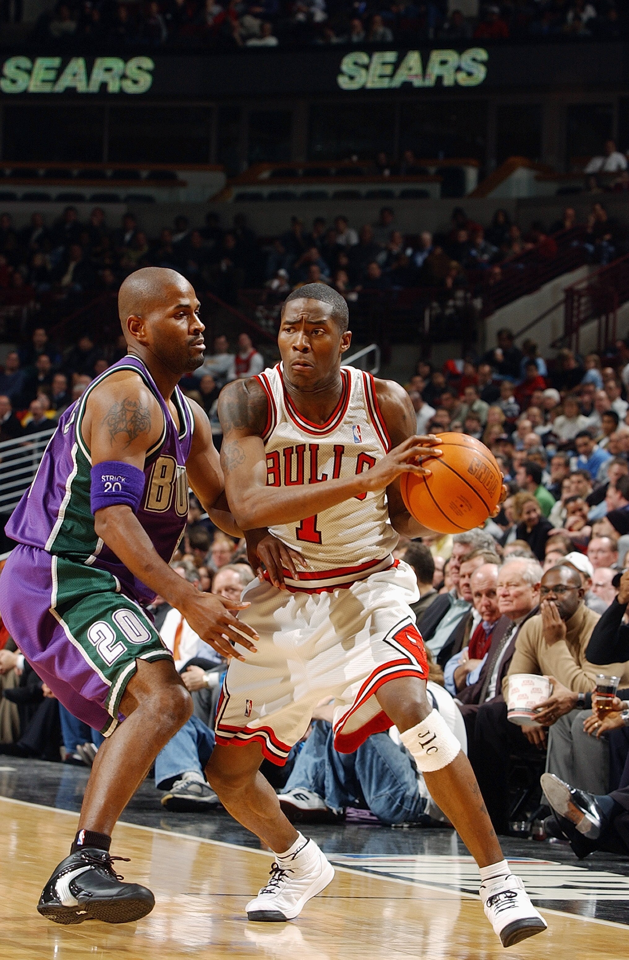 CHICAGO - DECEMBER 1:  Jamal Crawford #1 of the Chicago Bulls drives on Erick Strickland #20 of the Milwaukee Bucks on December 1, 2003 at the United Center in Chicago, Illinois. The Bulls won 97-87. NOTE TO USER: User expressly acknowledges and agrees th