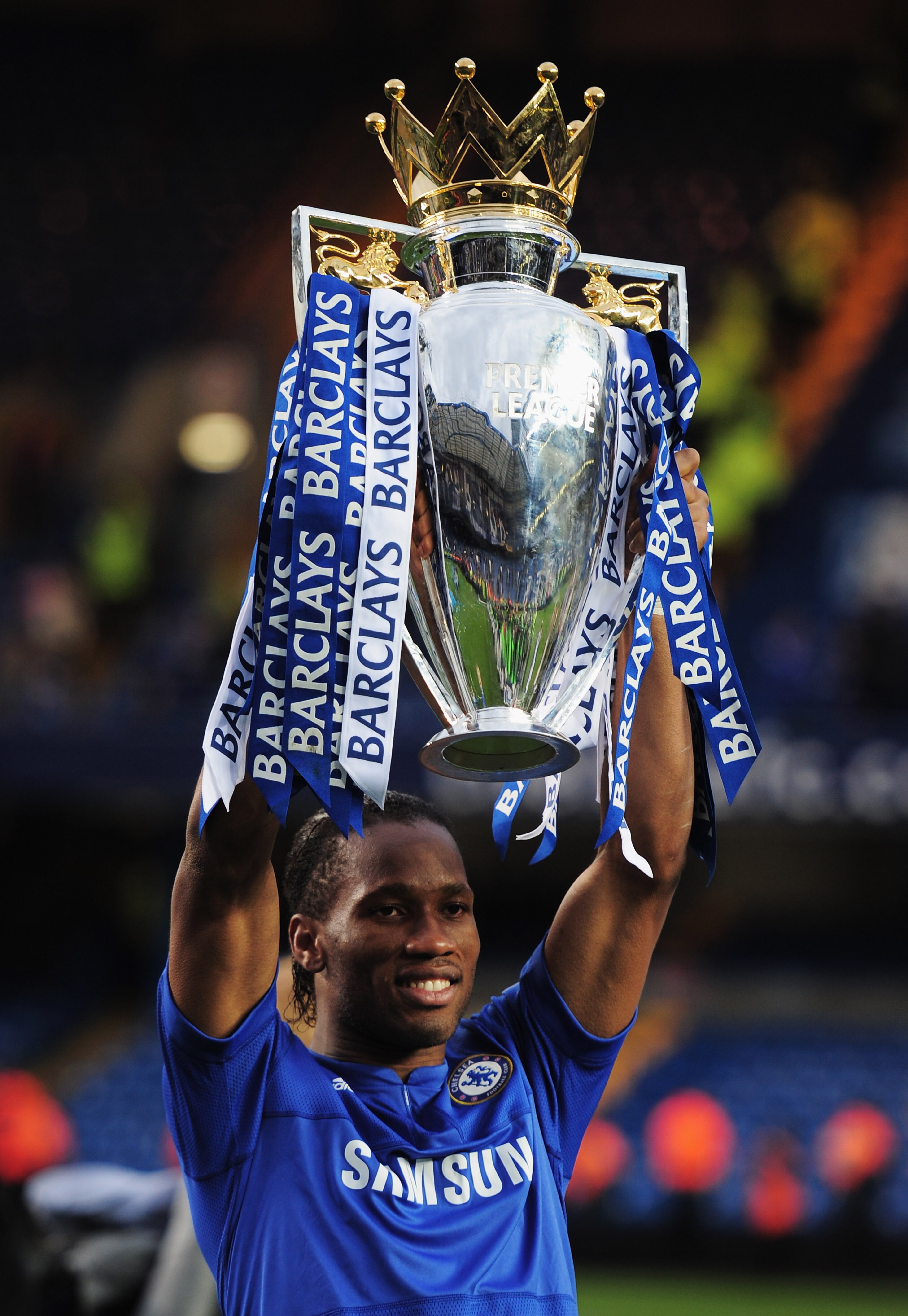 LONDON, ENGLAND - MAY 09: Didier Drogba of Chelsea celebrates with the trophy as they win the title after the Barclays Premier League match between Chelsea and Wigan Athletic at Stamford Bridge on May 9, 2010 in London, England. Chelsea won 8-0 to win th LONDON, ENGLAND - MAY 09: Didier Drogba of Chelsea celebrates with the trophy as they win the title after the Barclays Premier League match between Chelsea and Wigan Athletic at Stamford Bridge on May 9, 2010 in London, England. Chelsea won 8-0 to win th