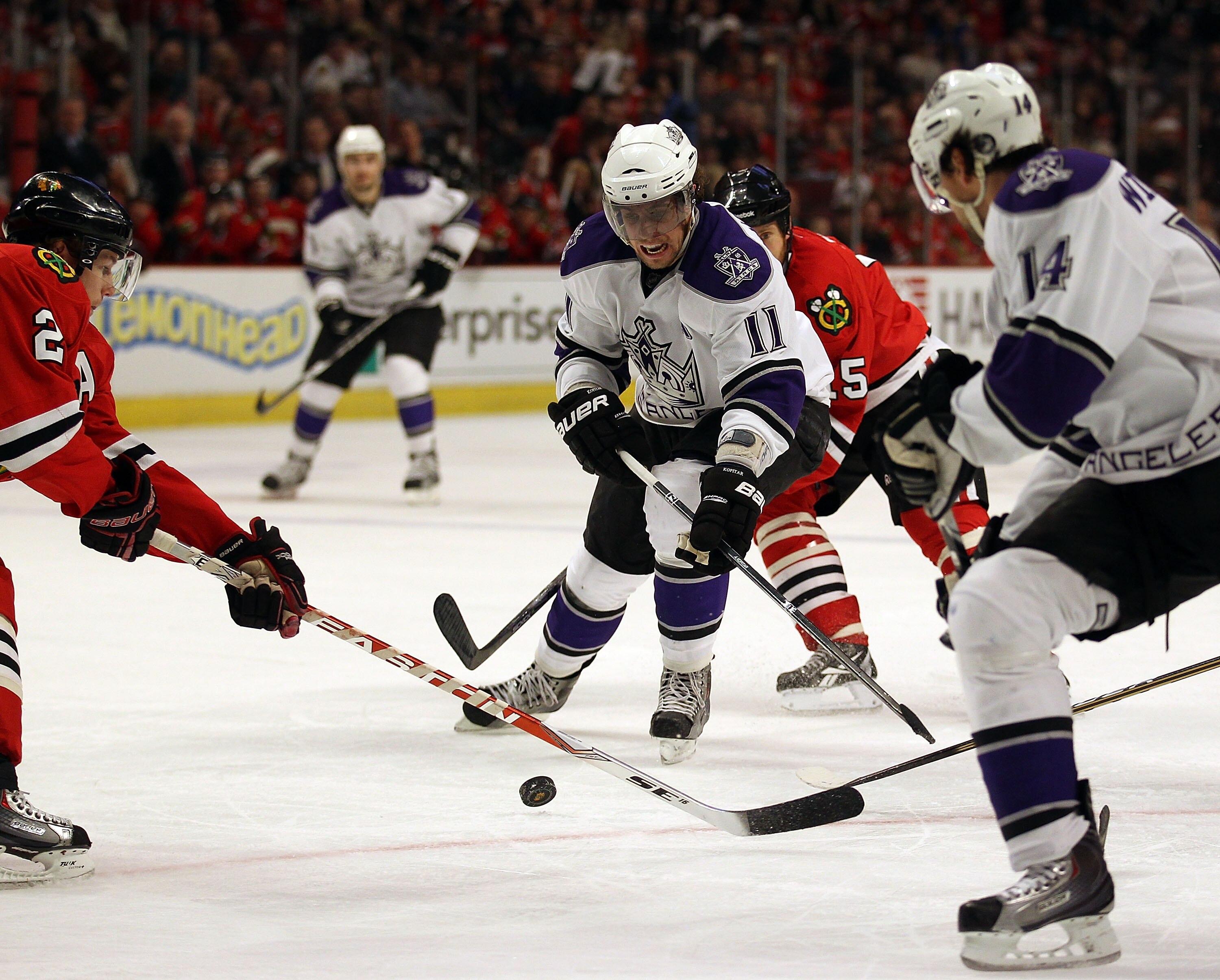CHICAGO, IL - DECEMBER 19: Anze Kopitar #11 of the Los Angeles Kings tries to pass to teammate Justin Williams #14 as Duncan Keith #2 of the Chicago Blackhawks knocks the puck away at the United Center on December 19, 2010 in Chicago, Illinois. The Blackh