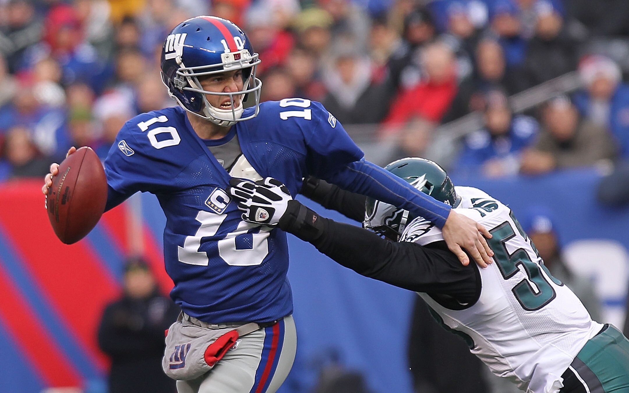 EAST RUTHERFORD, NJ - DECEMBER 19:  Eli Manning #10 of the New York Giants is sacked by Moise Fokou #53 of the Philadelphia Eagles at New Meadowlands Stadium on December 19, 2010 in East Rutherford, New Jersey.  (Photo by Nick Laham/Getty Images)