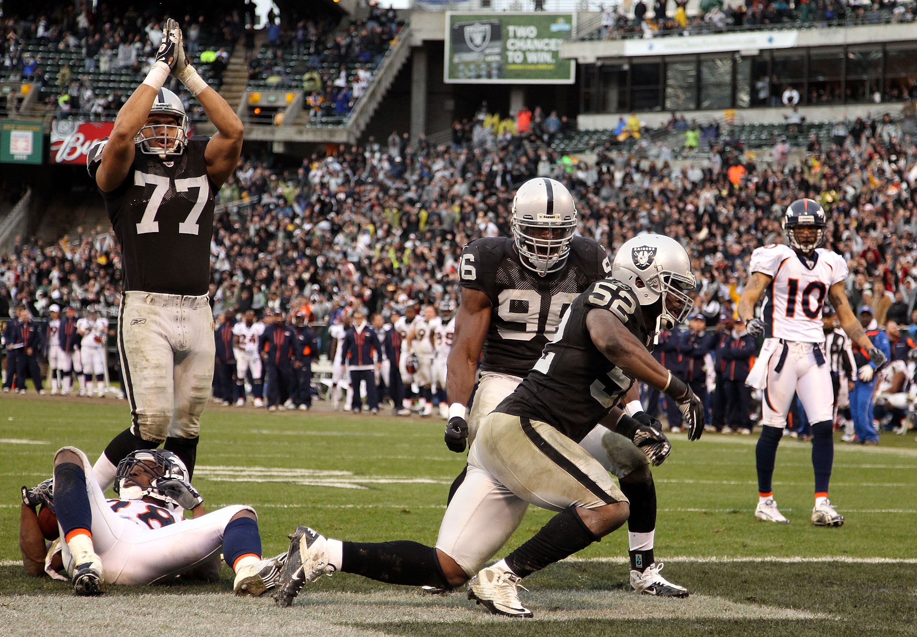 OAKLAND, CA - DECEMBER 19:  Quentin Groves #52 of the Oakland Raiders celebrates with Kamerion Wimbley #96 and Matt Shaughnessy #77 after he stopped Correll Buckhalter #28 of the Denver Broncos for a safety at Oakland-Alameda County Coliseum on December 1