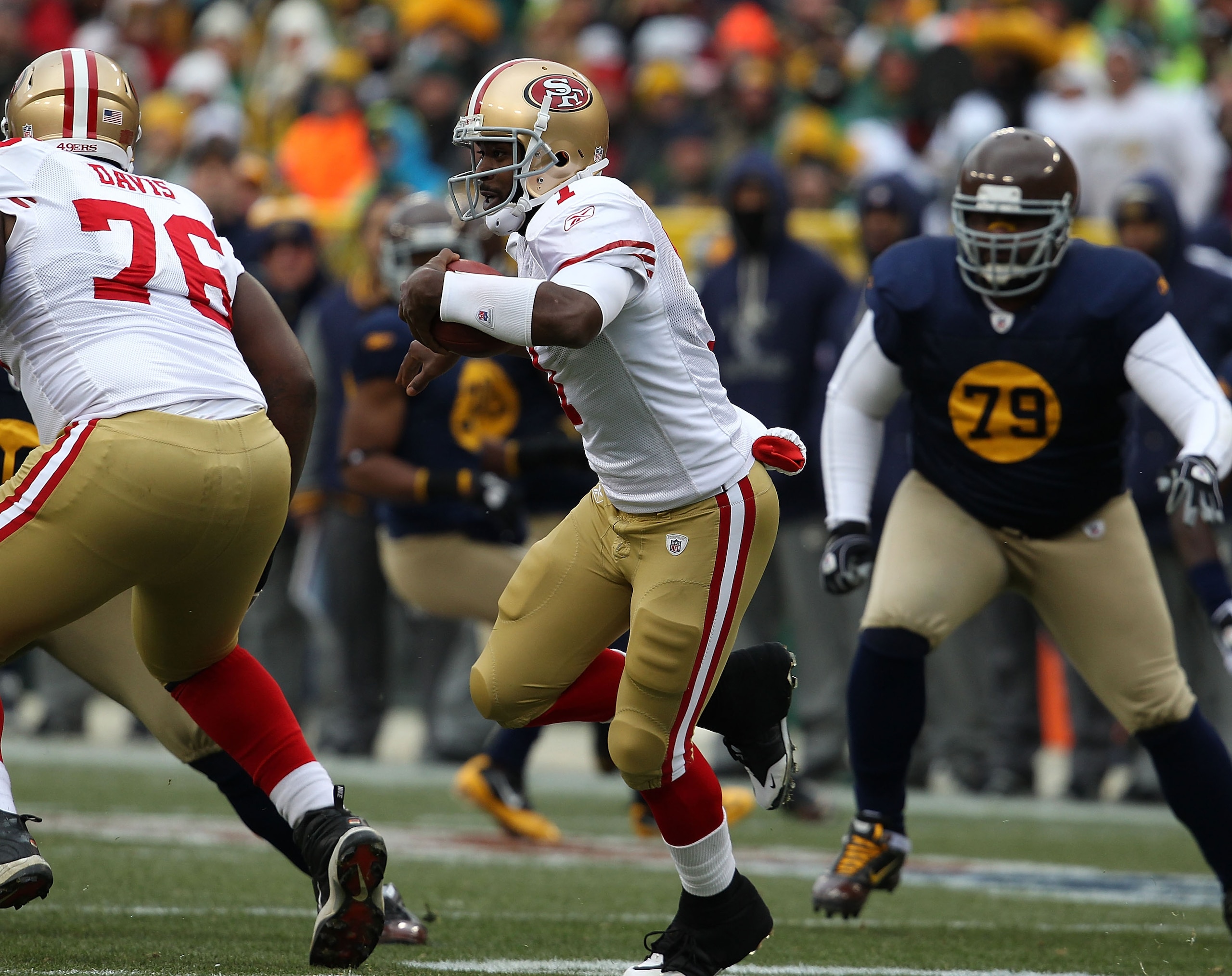 GREEN BAY, WI - DECEMBER 05: Troy Smith #1 of the San Francisco 49ers runs past teammate Anthony Davis #76 as Ryan Pickett #79 of the Green Bay Packers pursues the play at Lambeau Field on December 5, 2010 in Green Bay, Wisconsin. The Packers defeated the