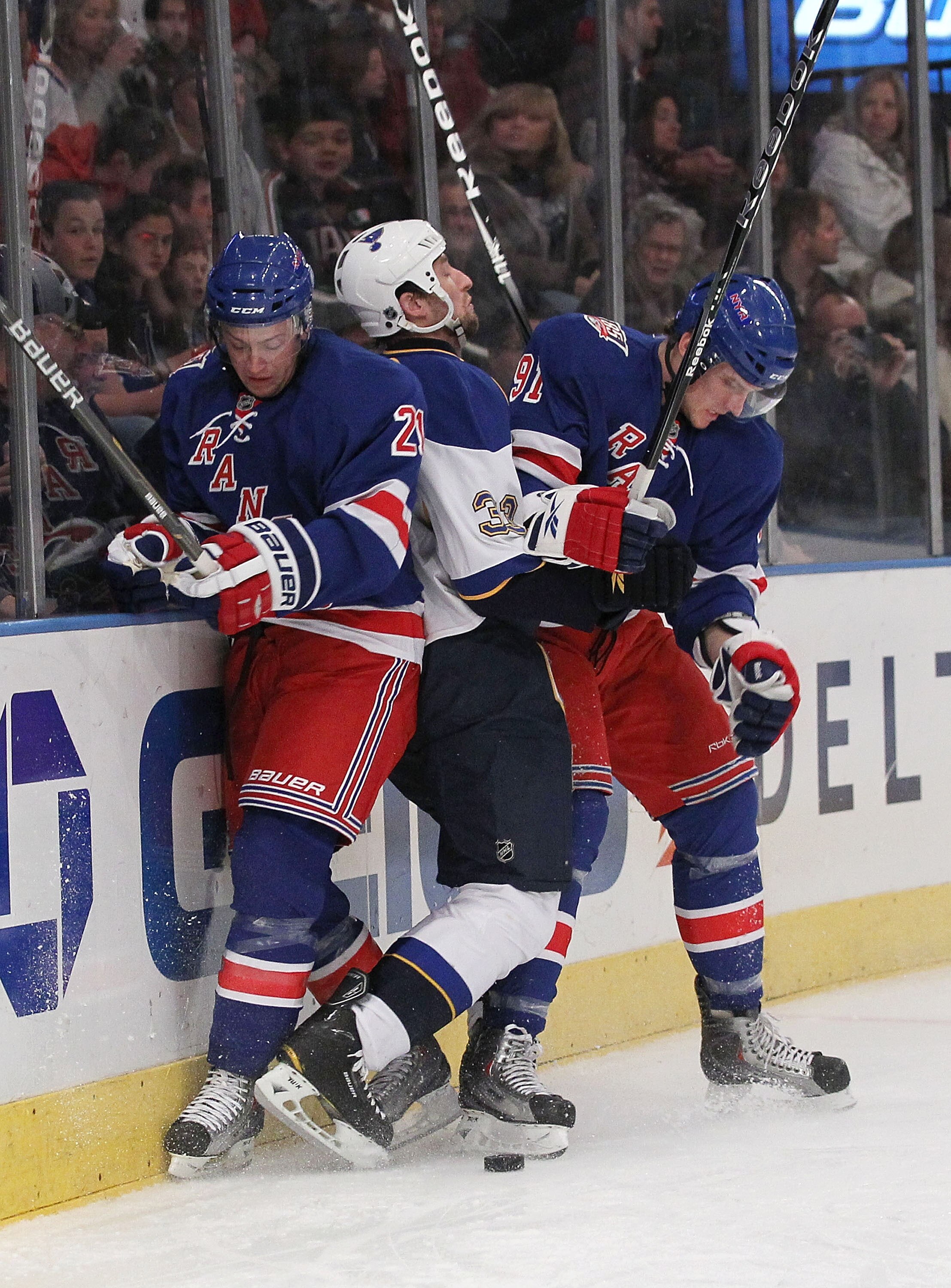 NEW YORK - NOVEMBER 07:  Derek Stephan #21 and Evgeny Grachev #91 of the New York Rangers sandwich Tyson Strachan #33 of the St. Louis Blues during their game on November 7, 2010 at Madison Square Garden in New York City, New York.  (Photo by Al Bello/Get