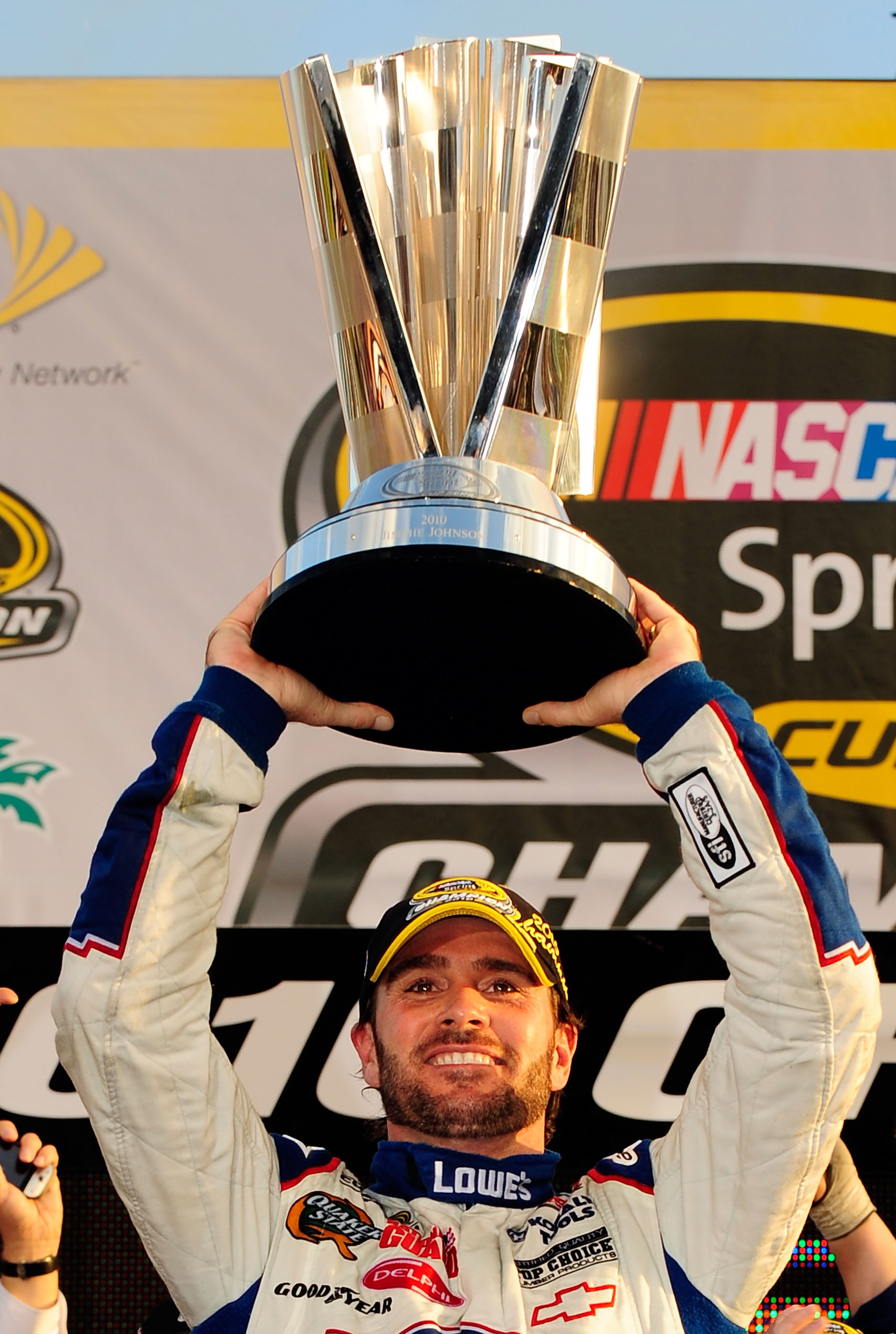 HOMESTEAD, FL - NOVEMBER 21:  Jimmie Johnson, driver of the #48 Lowe's Chevrolet, celebrates by hoisting the trophy after finishing in second place in the Ford 400 to clinch his fifth consecutive NASCAR Sprint Cup championship at Homestead-Miami Speedway