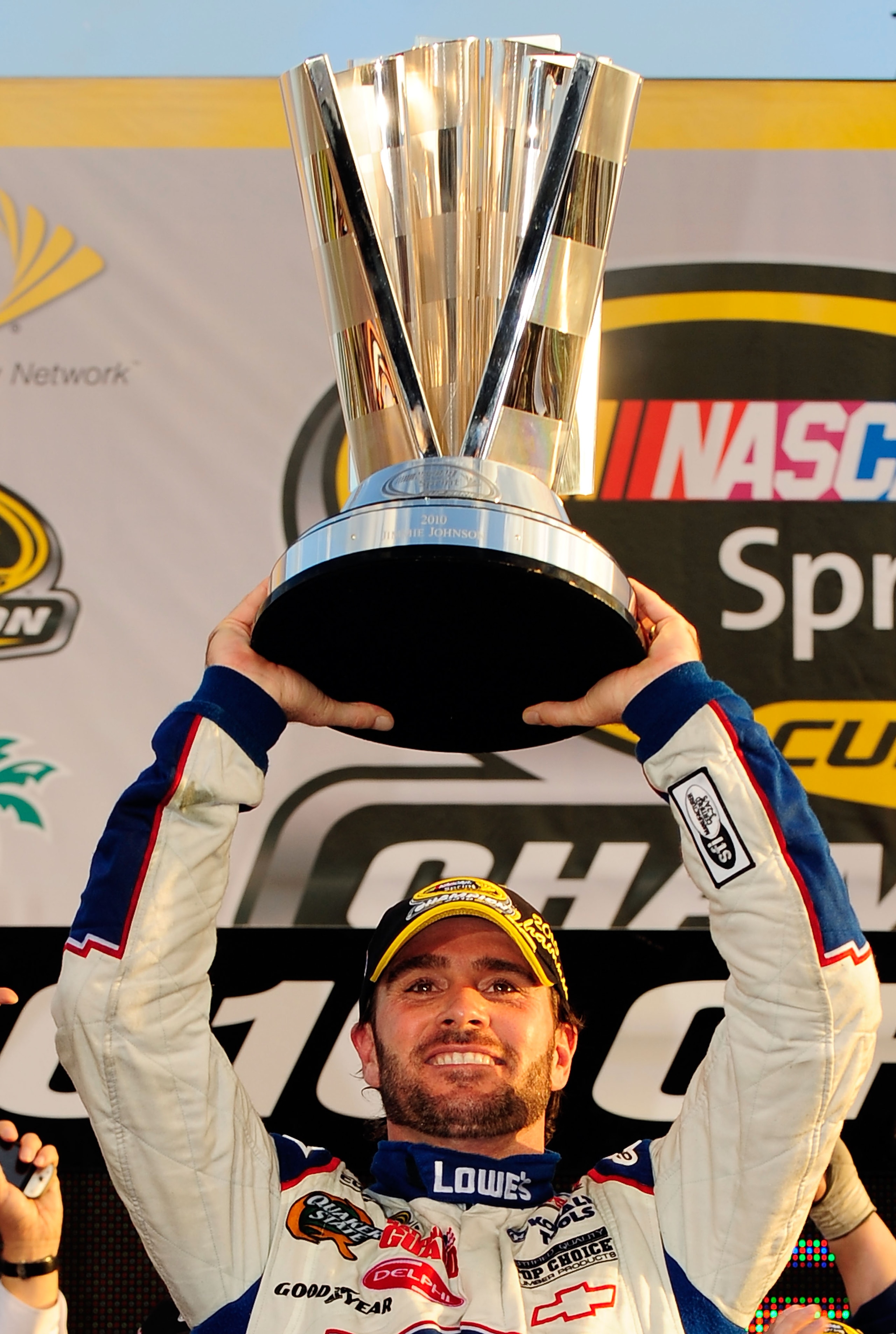 HOMESTEAD, FL - NOVEMBER 21:  Jimmie Johnson, driver of the #48 Lowe's Chevrolet, celebrates by hoisting the trophy after finishing in second place in the Ford 400 to clinch his fifth consecutive NASCAR Sprint Cup championship at Homestead-Miami Speedway