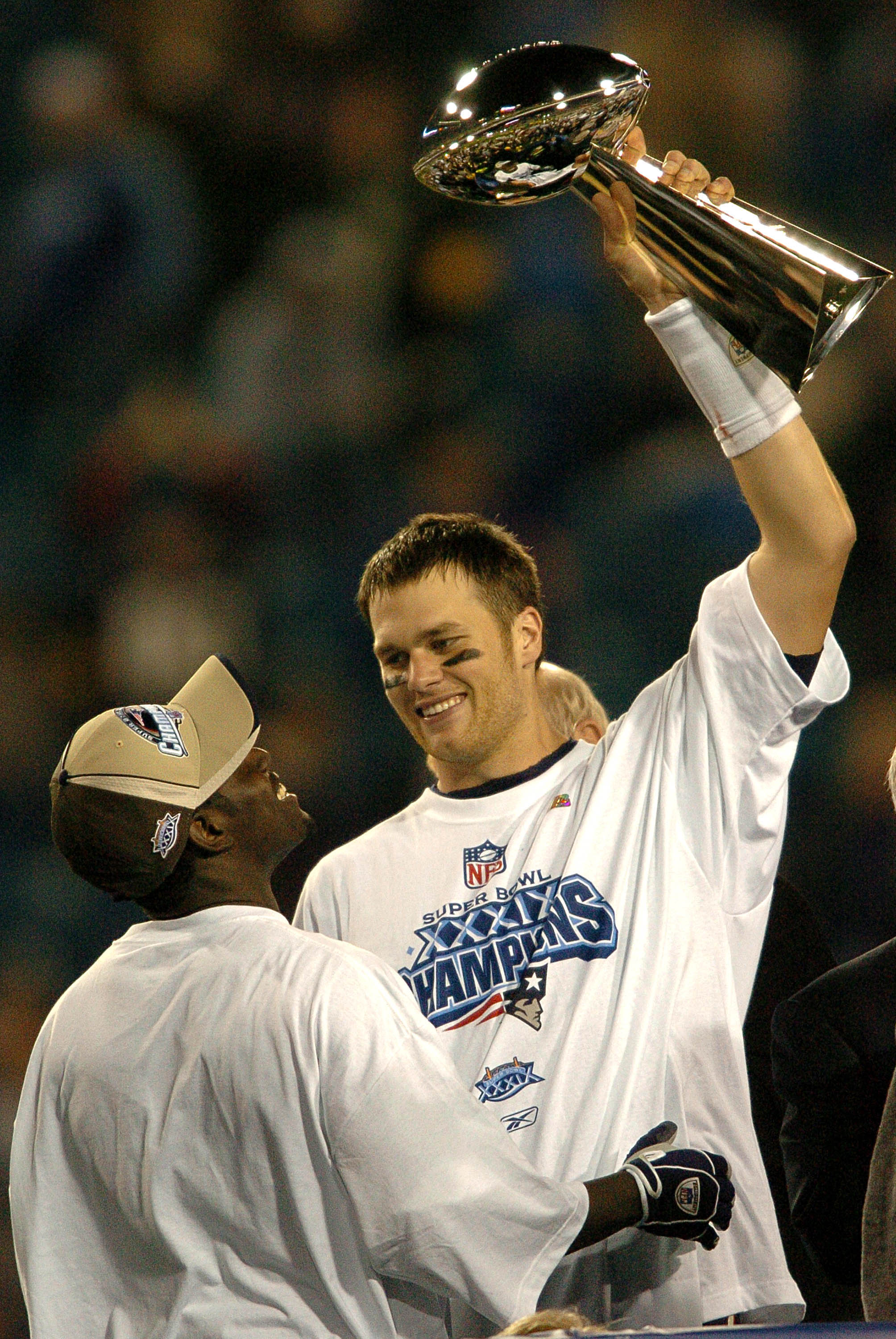 Tom Brady holds the Vince Lombardi Trophy as he stands on the podium with Deion Branch after The New England Patriots defeated The Philadelphia Eagles in Super Bowl XXXIX at Alltel Staduim in Jacksonville, Florida. (Photo by Steve Grayson/Getty Images)