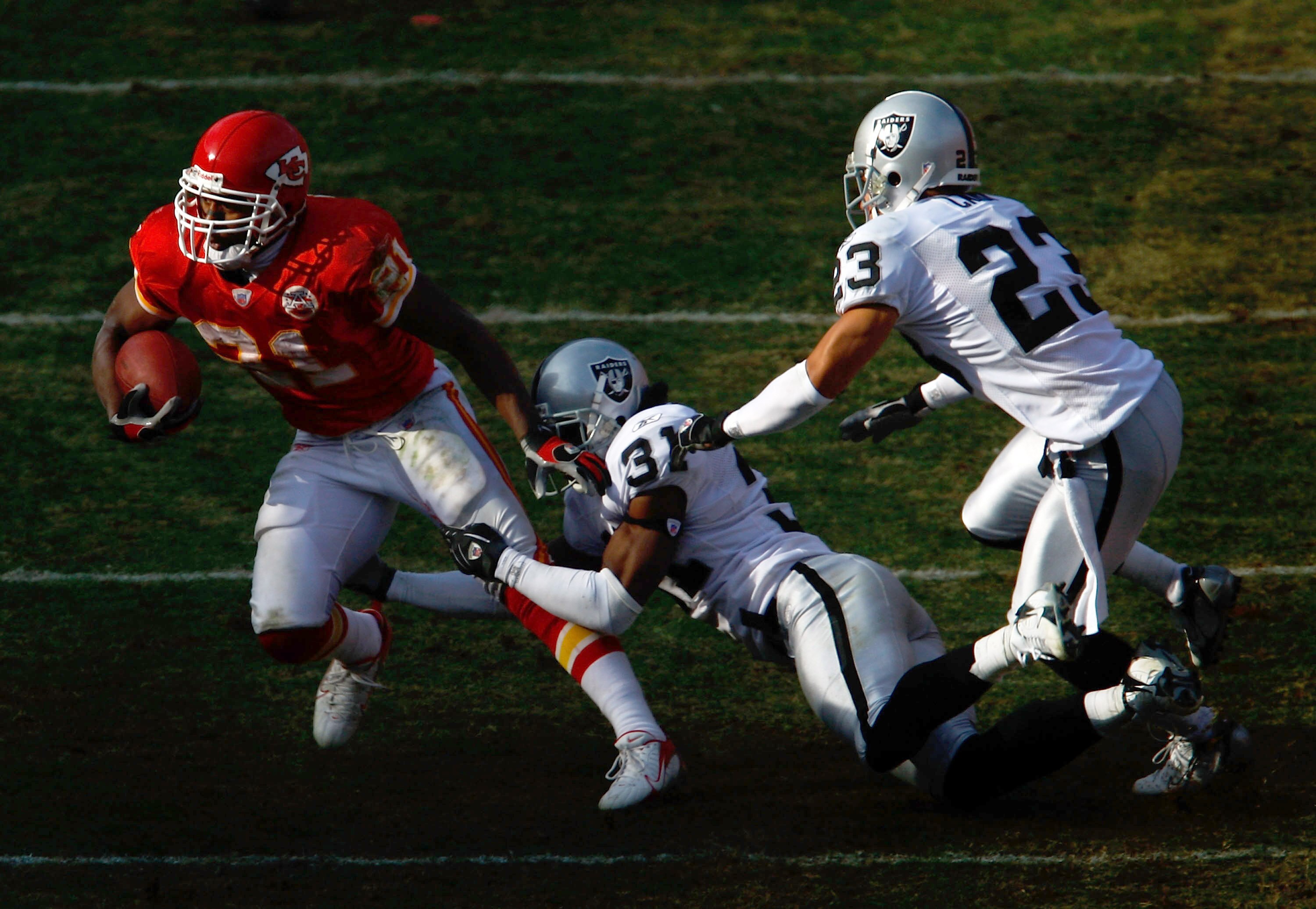 KANSAS CITY, MO - NOVEMBER 25:  Kolby Smith #21 of the Kansas City Chiefs carries the ball as Hiram Eugene #31 and Chris Carr #23 of the Oakland Raiders defend during the game on November 25, 2007 at Arrowhead Stadium in Kansas City, Missouri.  (Photo by 
