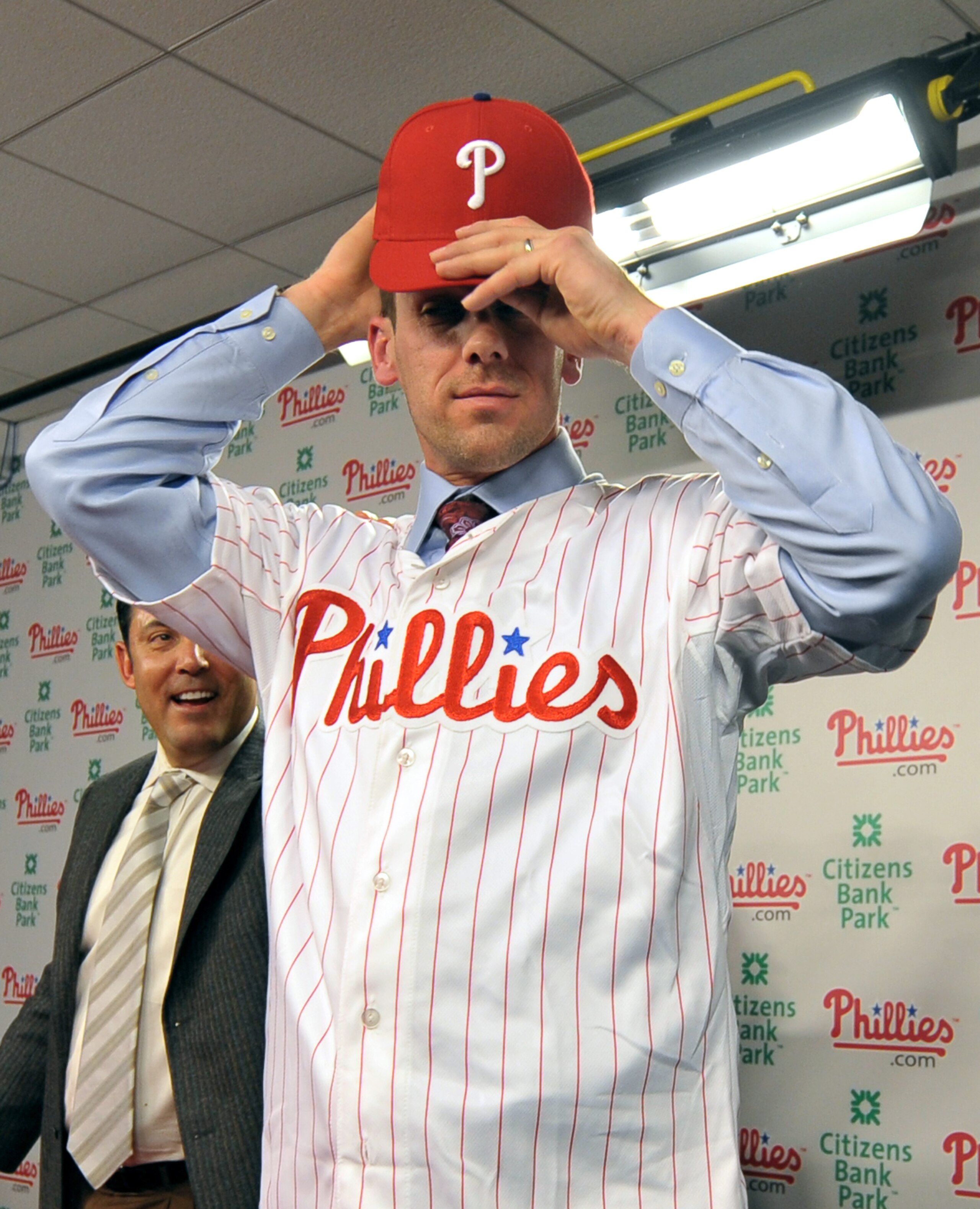 PHILADELPHIA - DECEMBER 15: Pitcher Cliff Lee #33 of the Philadelphia Phillies adjusts his hat after being introduced to the media during a press conference as Philadelphia Phillies general manager Ruben Amaro Jr. (L) looks on at Citizens Bank Park on Dec PHILADELPHIA - DECEMBER 15: Pitcher Cliff Lee #33 of the Philadelphia Phillies adjusts his hat after being introduced to the media during a press conference as Philadelphia Phillies general manager Ruben Amaro Jr. (L) looks on at Citizens Bank Park on Dec