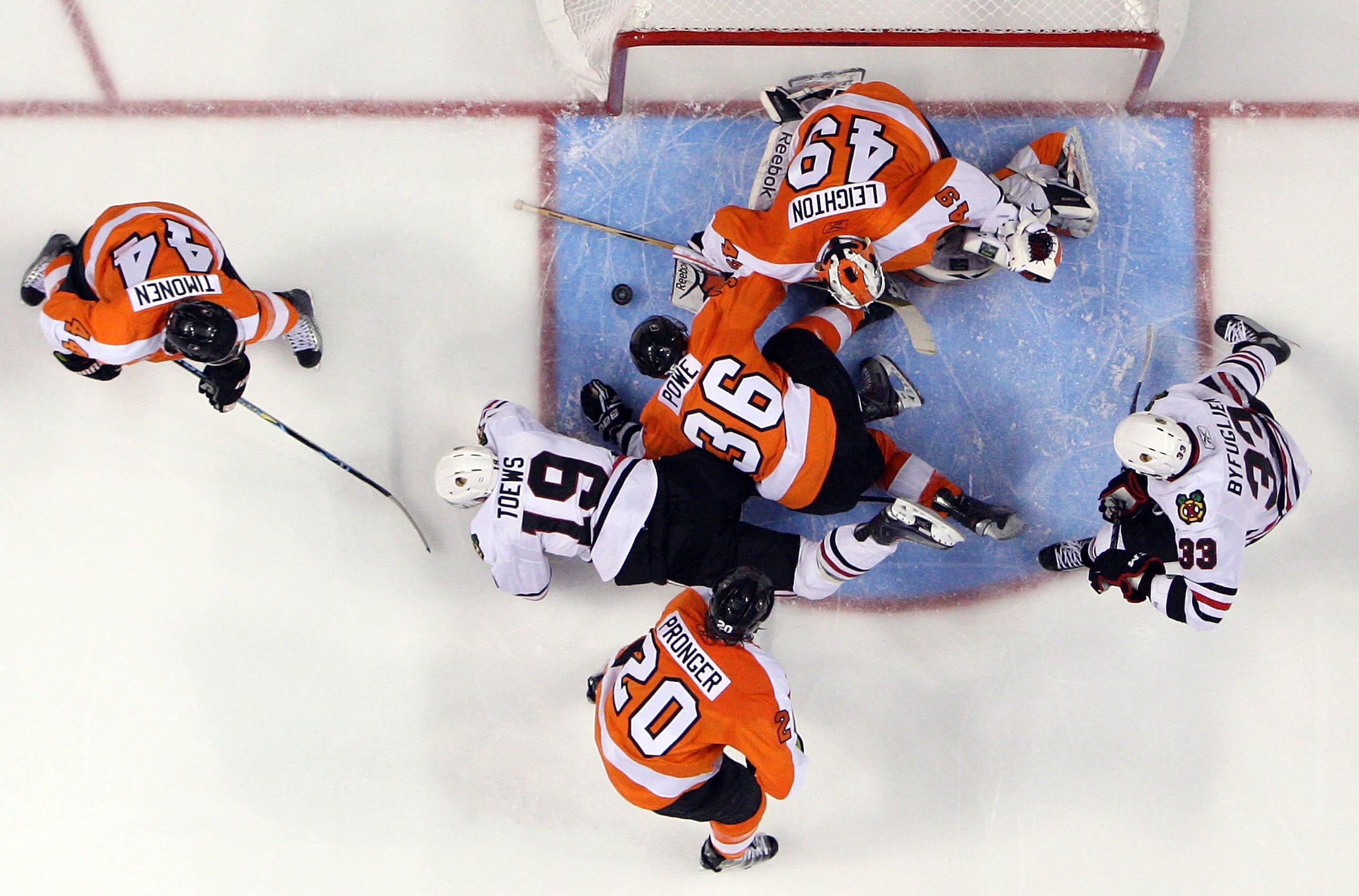 PHILADELPHIA - JUNE 09:  Jonathan Toews #19 of the Chicago Blackhawks is stopped by Michael Leighton #49 and Darroll Powe #36 of the Philadelphia Flyers in Game Six of the 2010 NHL Stanley Cup Final at the Wachovia Center on June 9, 2010 in Philadelphia,