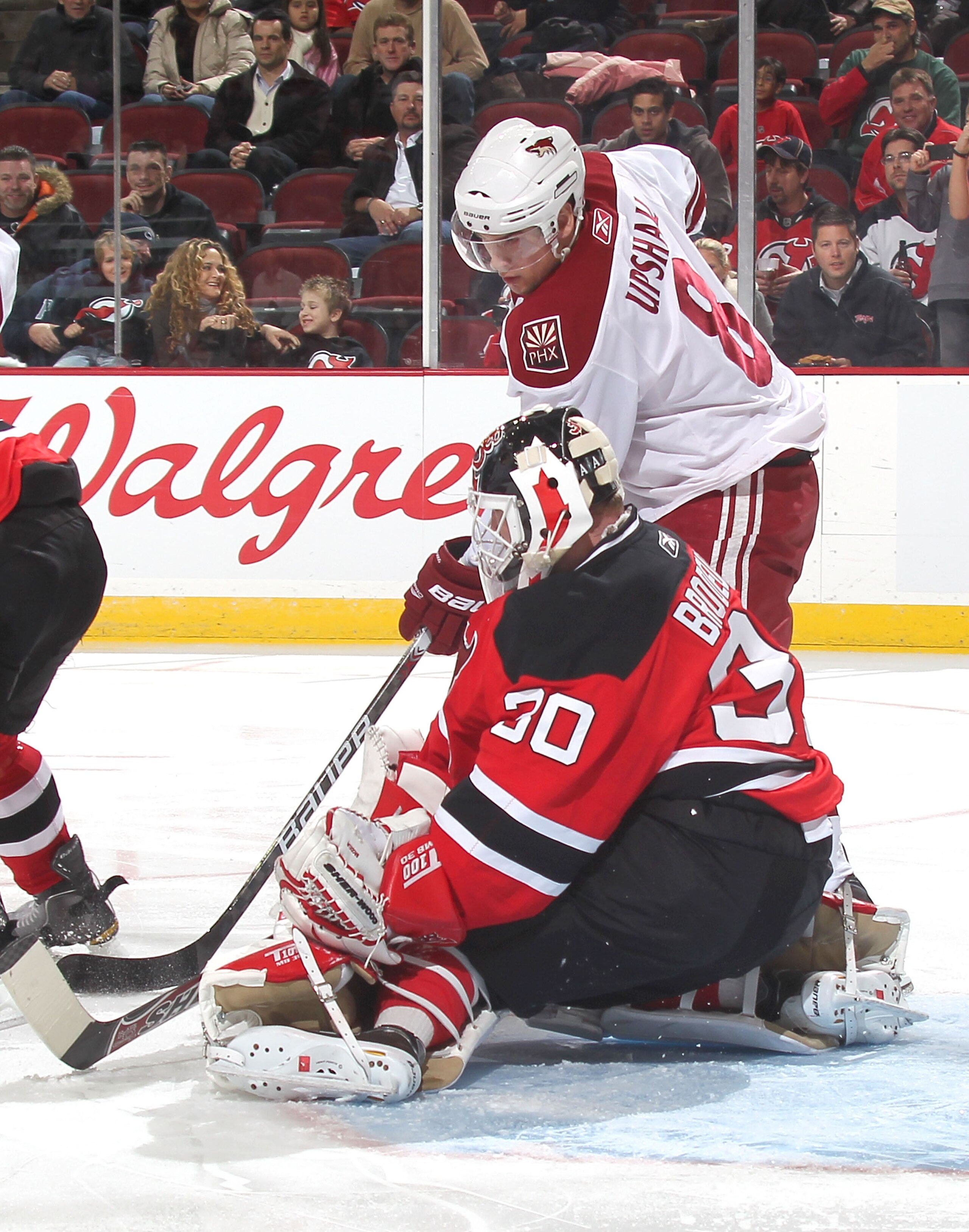 NEWARK, NJ - DECEMBER 15:  Goalie Martin Brodeur #30 of the New Jersey Devils defends the goal against Scottie Upshall #8 of the Phoenix Coyotes during a hockey game at the Prudential Center on December 15, 2010 in Newark, New Jersey.  (Photo by Paul Bere
